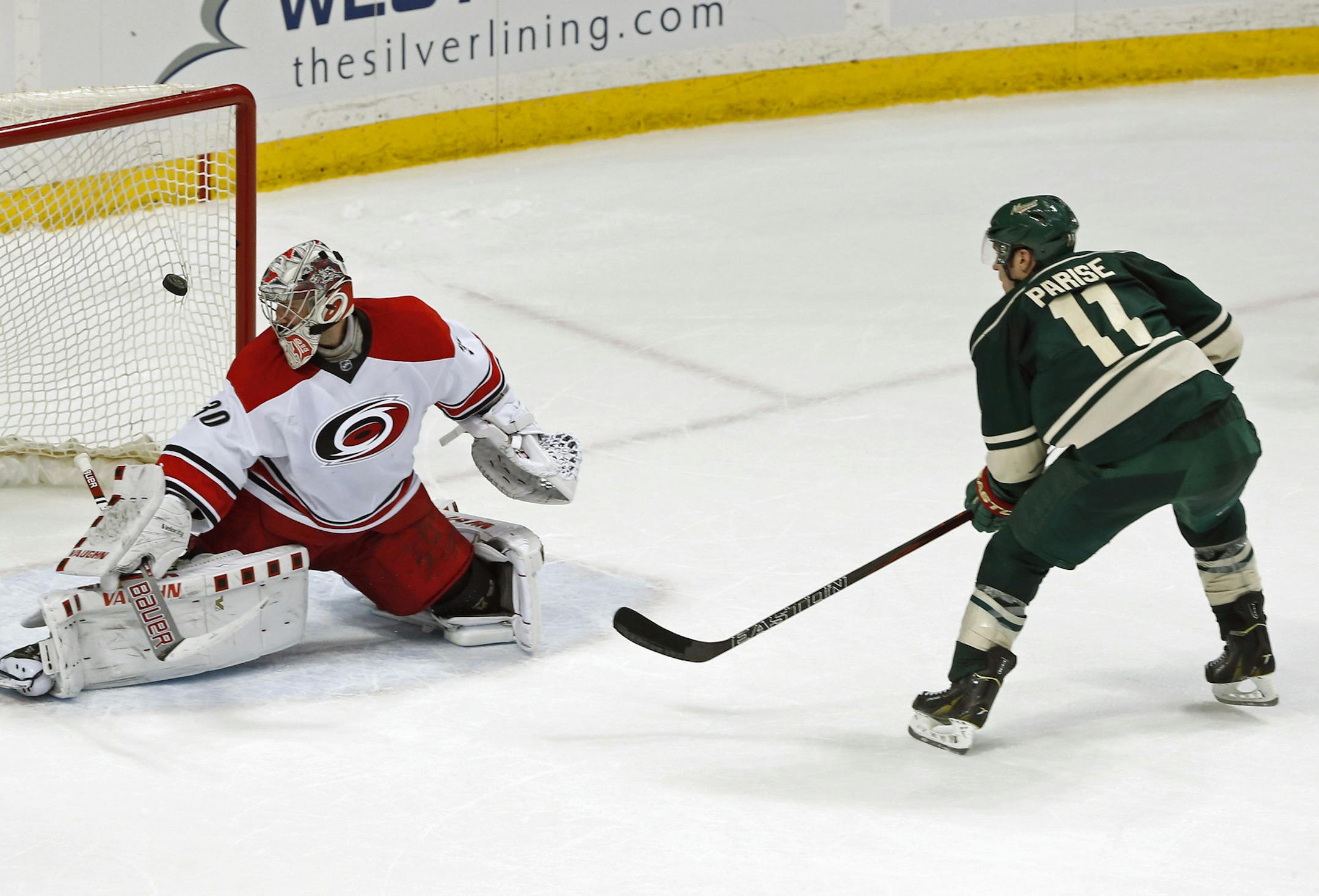 Minnesota Wild's Zach Parise, right, scores the winning shootout goal against Carolina Hurricanes goalie Cam Ward in an NHL hockey game Saturday, March 19, 2016, in St. Paul, Minn. (AP Photo/Jim Mone)