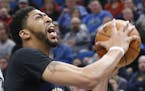 New Orleans Pelicans' Anthony Davis, right, lays up as Minnesota Timberwolves' Kris Dunn defends during the second half of an NBA basketball game Frid