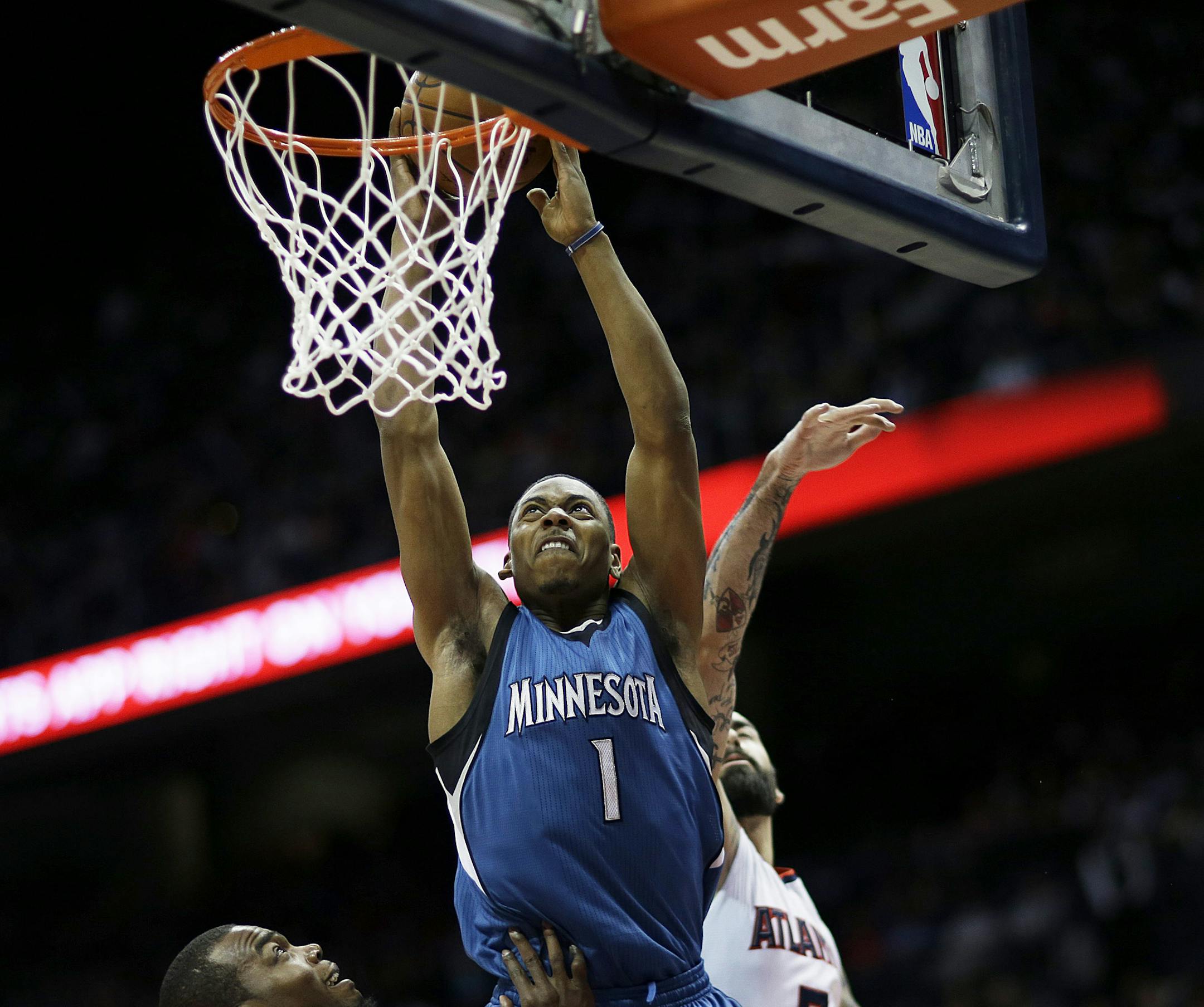 Minnesota Timberwolves' Glenn Robinson III, center, puts up a layup to score against the defense of Atlanta Hawks' Paul Millsap, left, and Pero Antic, right of Macedonia, in the third quarter of an NBA basketball game, Sunday, Jan. 25, 2015, in Atlanta. The Hawks beat the Timberwolves 112-100 to win their 16th game in a row. (AP Photo/David Goldman)