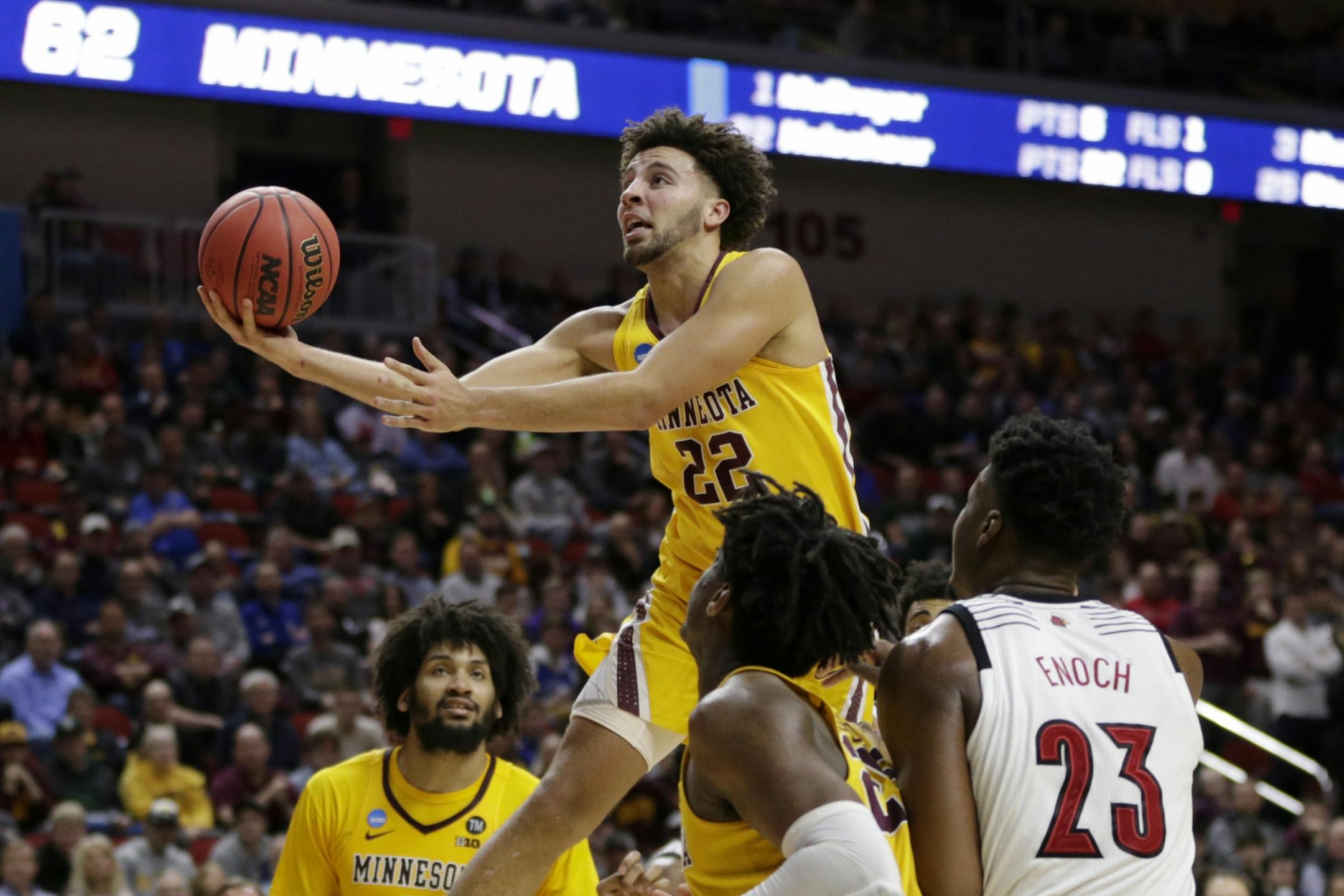 Minnesota's Gabe Kalscheur (22) goes for a layup as Louisville's Steven Enoch (23) watches, during the second half of a first round men's college basketball game in the NCAA Tournament in Des Moines, Iowa, Thursday, March 21, 2019.