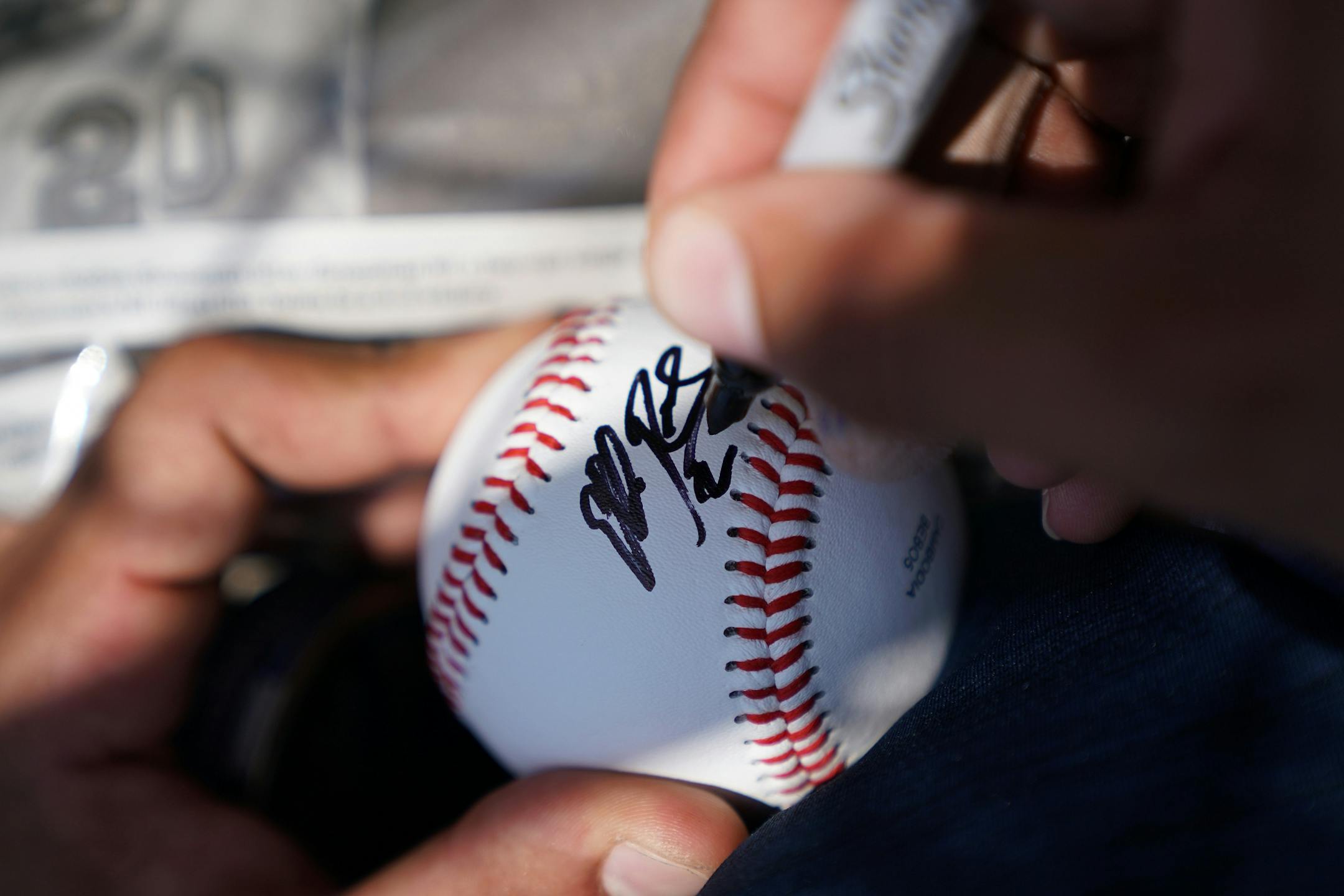 Minnesota Twins left fielder Eddie Rosario (20) signed an autograph for a fan after informal drills Saturday.