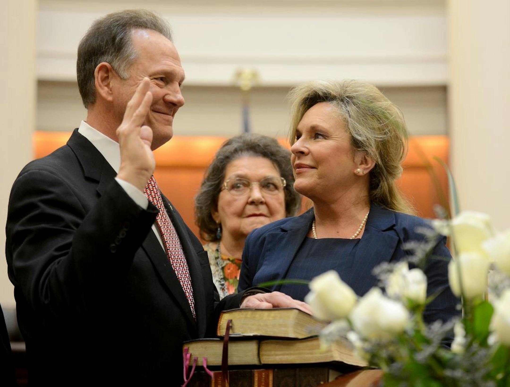 Alabama Chief Justice Roy Moore takes the oath of office Friday, Jan. 11, 2013, as his wife, Kayla, looks on, at the Heflin-Torbert Judicial Building in Montgomery, Ala. Moore promised continued loyalty to God first as he took the oath of office Friday to become chief justice of Alabama's Supreme Court, almost a decade after he was removed from the same post over a church-state dispute.
