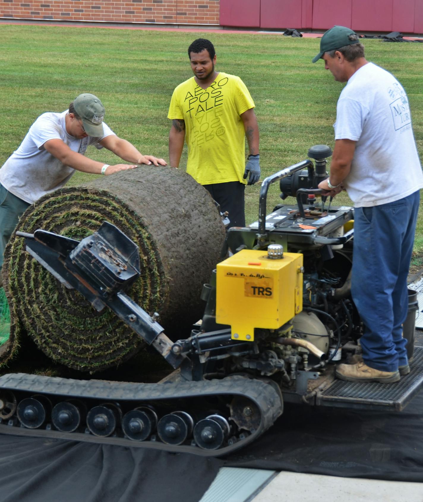 The artificial turf is being covered and grass is being put in for a soccer match this weekend.