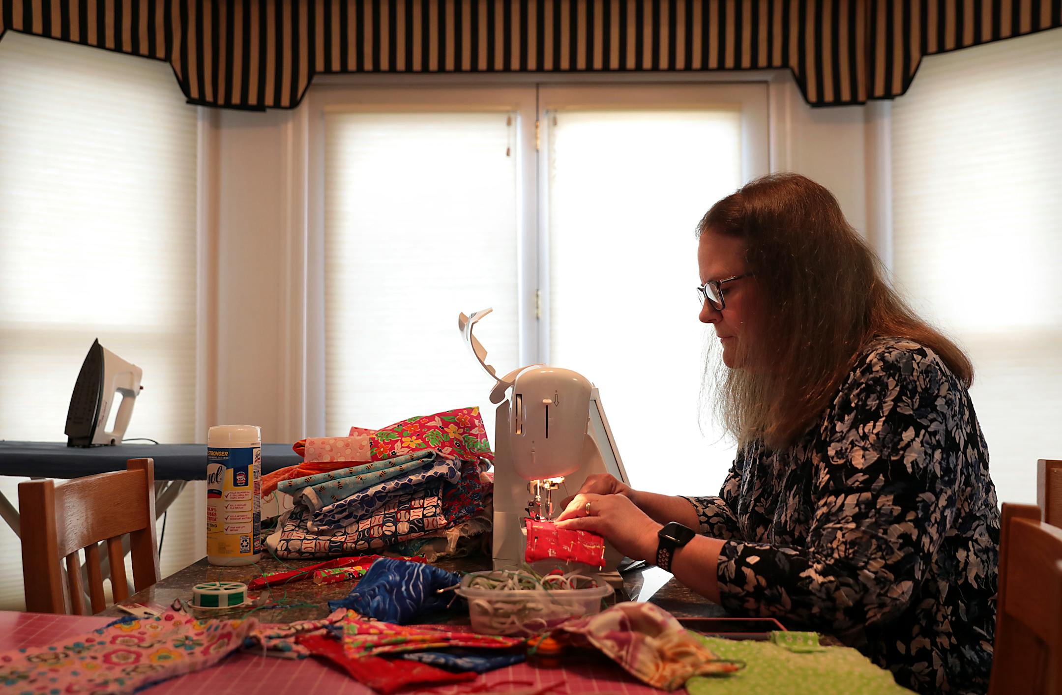 Linda Helton works making face masks in the kitchen of her Webster Groves home on Monday, March 23, 2020. Spending an estimated 35 minutes on each mask, her first batch will go to an area hospice. "This way the families can say goodbye," said Helton, who learned to sew as a child from her mother. She also watched as her mother rolled bandages during the Vietnam war. "She'd do that every night without any idea who would use them. There's no reason I can't be my mom in this generation." (Robert Co