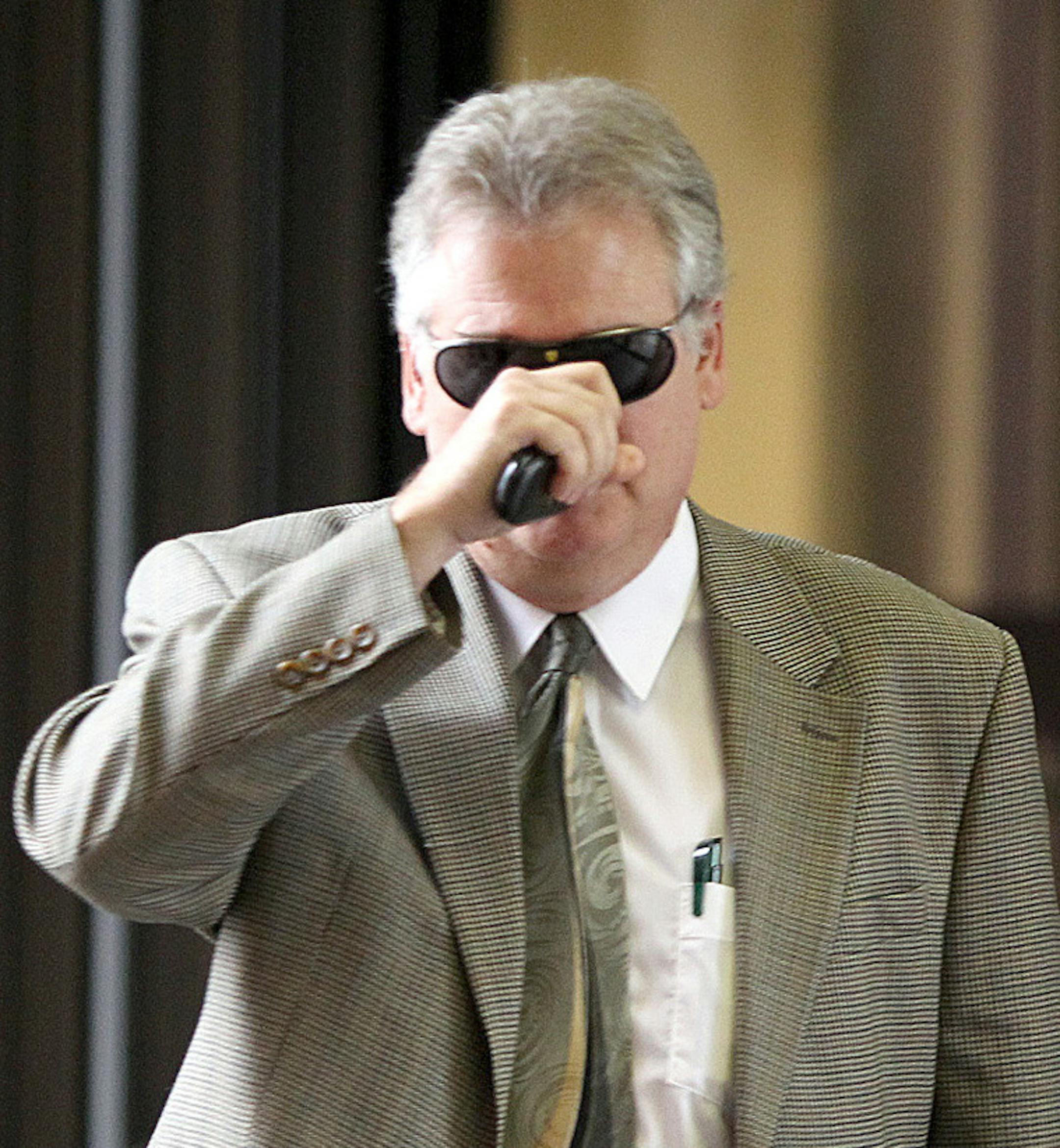 Frank Vennes covered his face as he left court Wednesday after talking about his role in the Ponzi scheme.