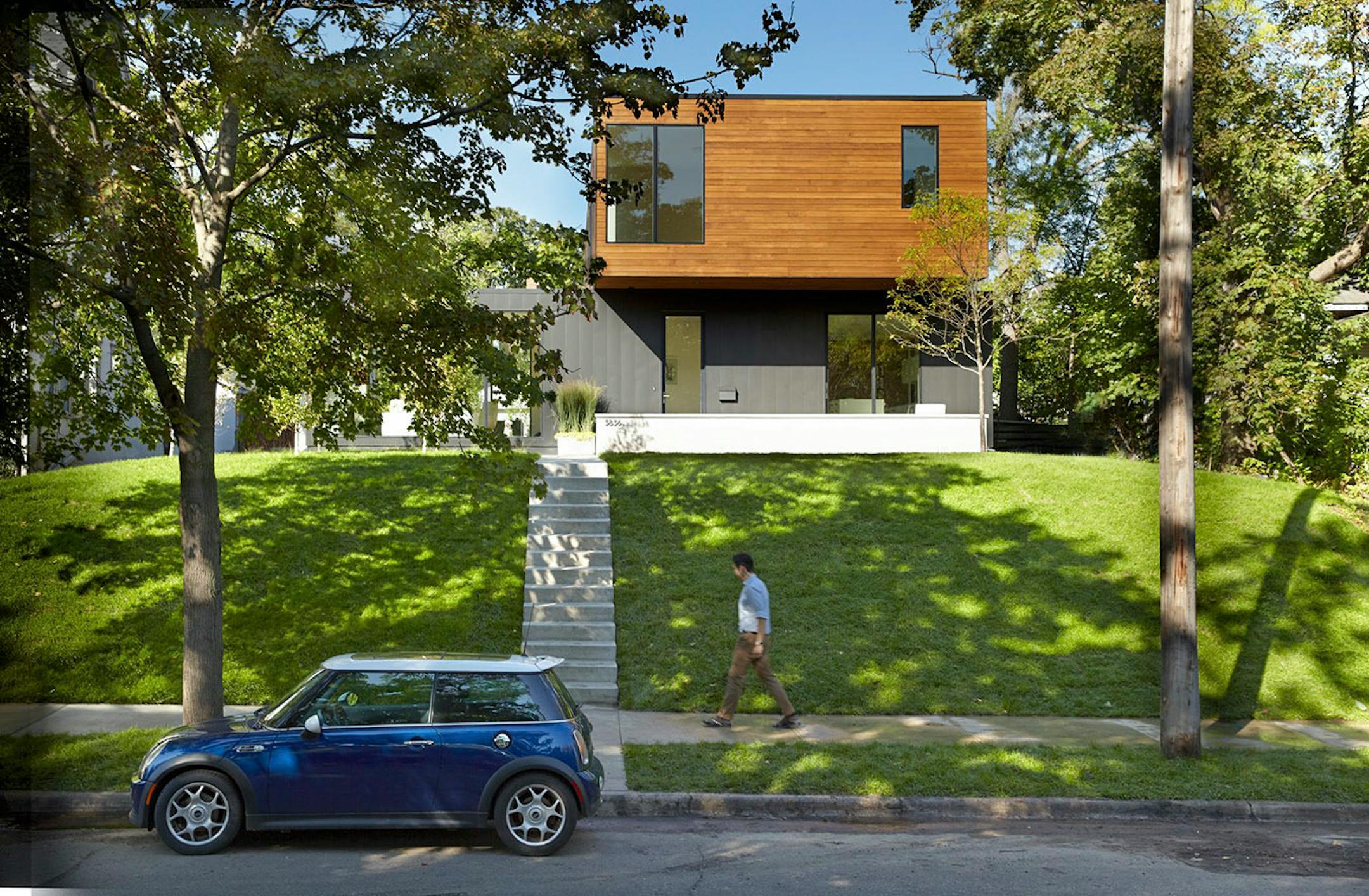 The new modern residence sits back on a hill in an older Minneapolis neighborhood with primarily traditional homes.