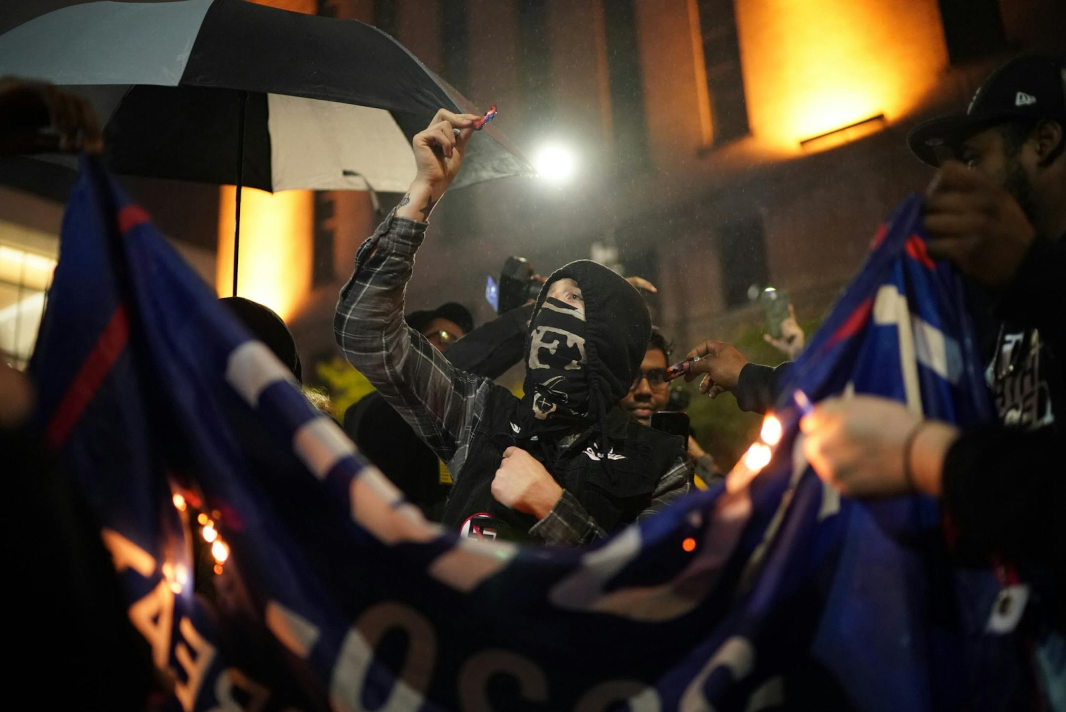 Protesters burn a Trump flag outside Target Center.