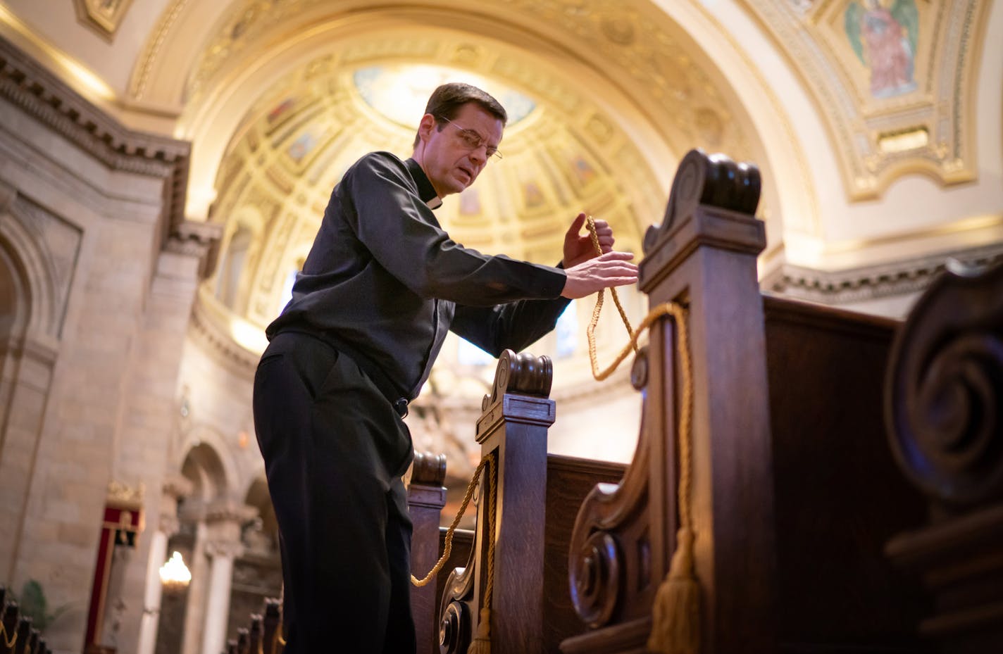 Fr. John Ubel roped off two pews, leaving every third one open, according to a seating chart to evenly space 250 parishioners for this weekend's Mass at the Cathedral of St Paul. ] GLEN STUBBE • glen.stubbe@startribune.com Thursday, May 28, 2020 The Cathedral of St Paul is preparing to reopen for the first time since March. They're putting up signage and other safety precautions to comply with state health guidelines. They are roping off pews etc. Photo could be of news signs made that are not b