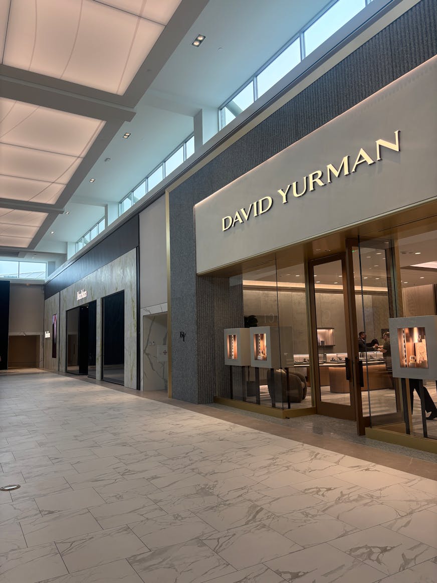 David Yurman and Max Mara storefronts are lightly illuminated.