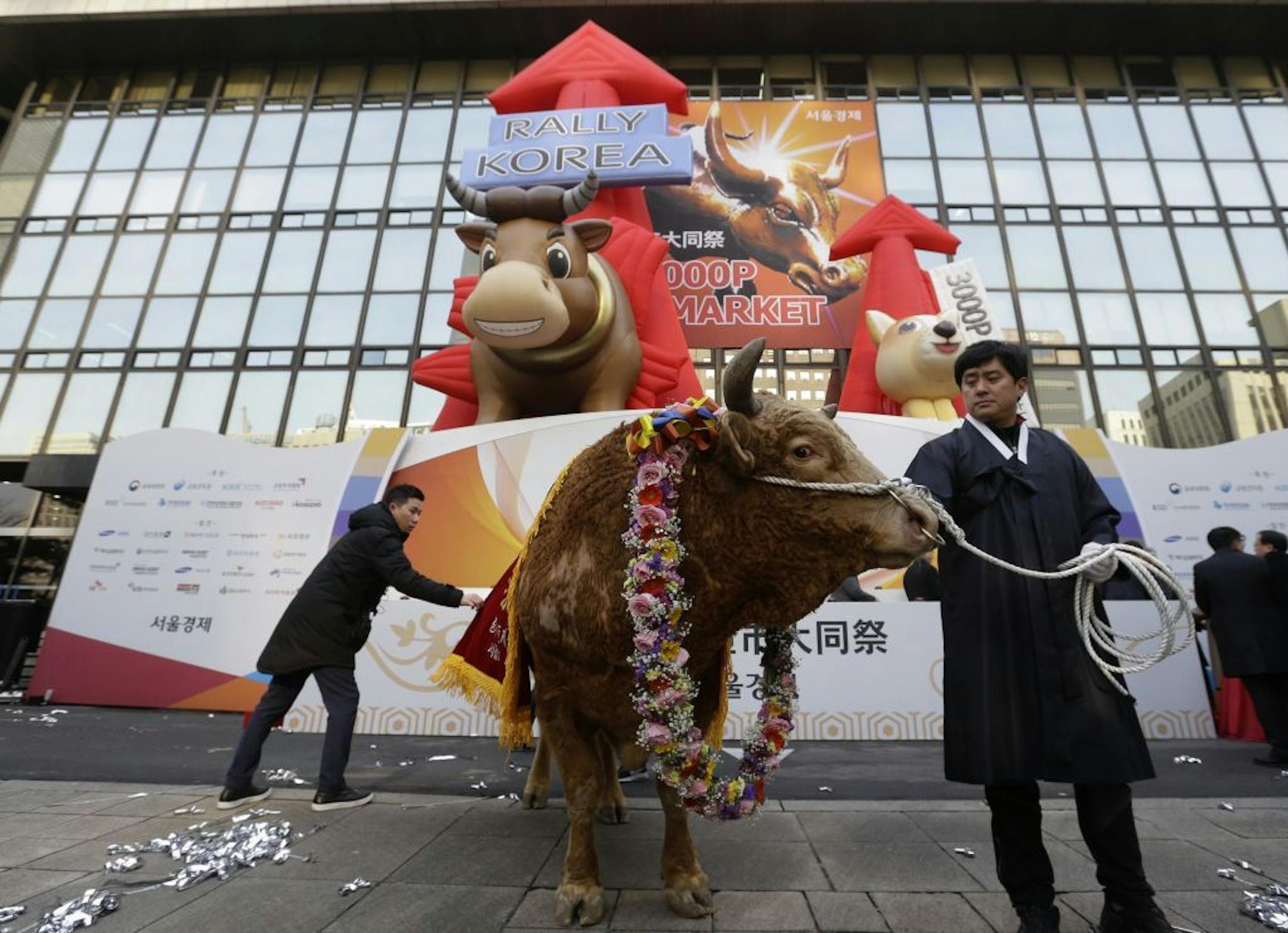 A farmer parades with a bull during the opening of this year's trading at the Korea Exchange in Seoul, South Korea, Tuesday, Jan. 2, 2018.