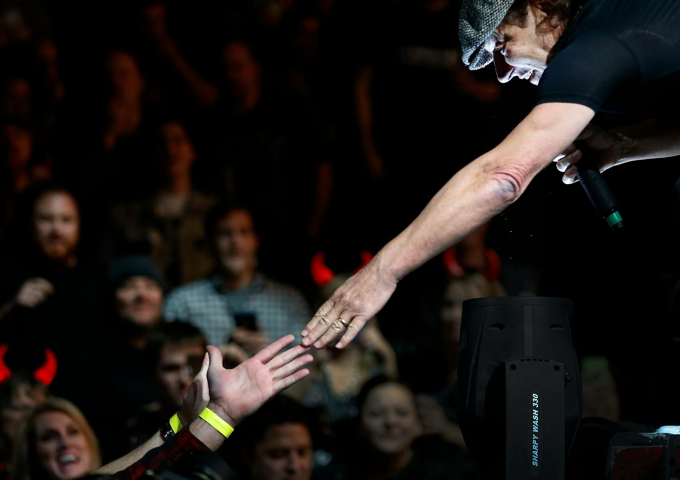 Lead singer Brian Johnson reached out to a fan as AC/DC performed at the Xcel Energy Center on Sunday night. ] CARLOS GONZALEZ cgonzalez@startribune.com - February 14, 2016, New St. Paul, MN, Xcel Energy Center, AC/DC Concert