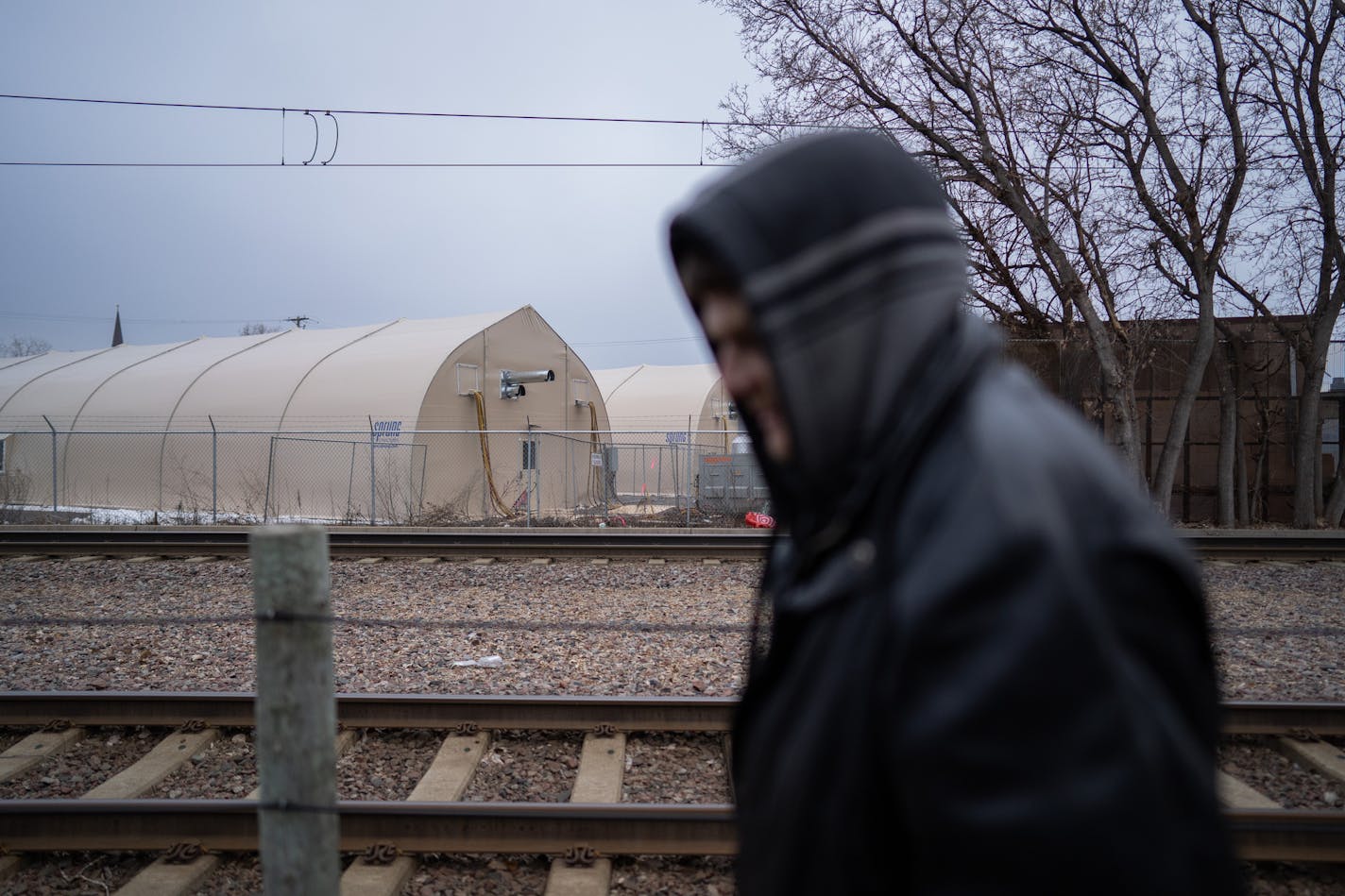 Aaron Thomas Schaer, 45, moved to the navigation center (tents in background) after an extended stay at the Hiawatha encampment. Schaer is struggling with heroin addiction. ] MARK VANCLEAVE ¥ Many former residents of the tent encampment along Hiawatha Ave. are now hunkering down for winter in a 'navigation center' next to the Franklin Ave. light rail station. The three large heated tents provide a warm and dry place to spend Christmas. Photographed Tuesday, Dec. 25, 2018.