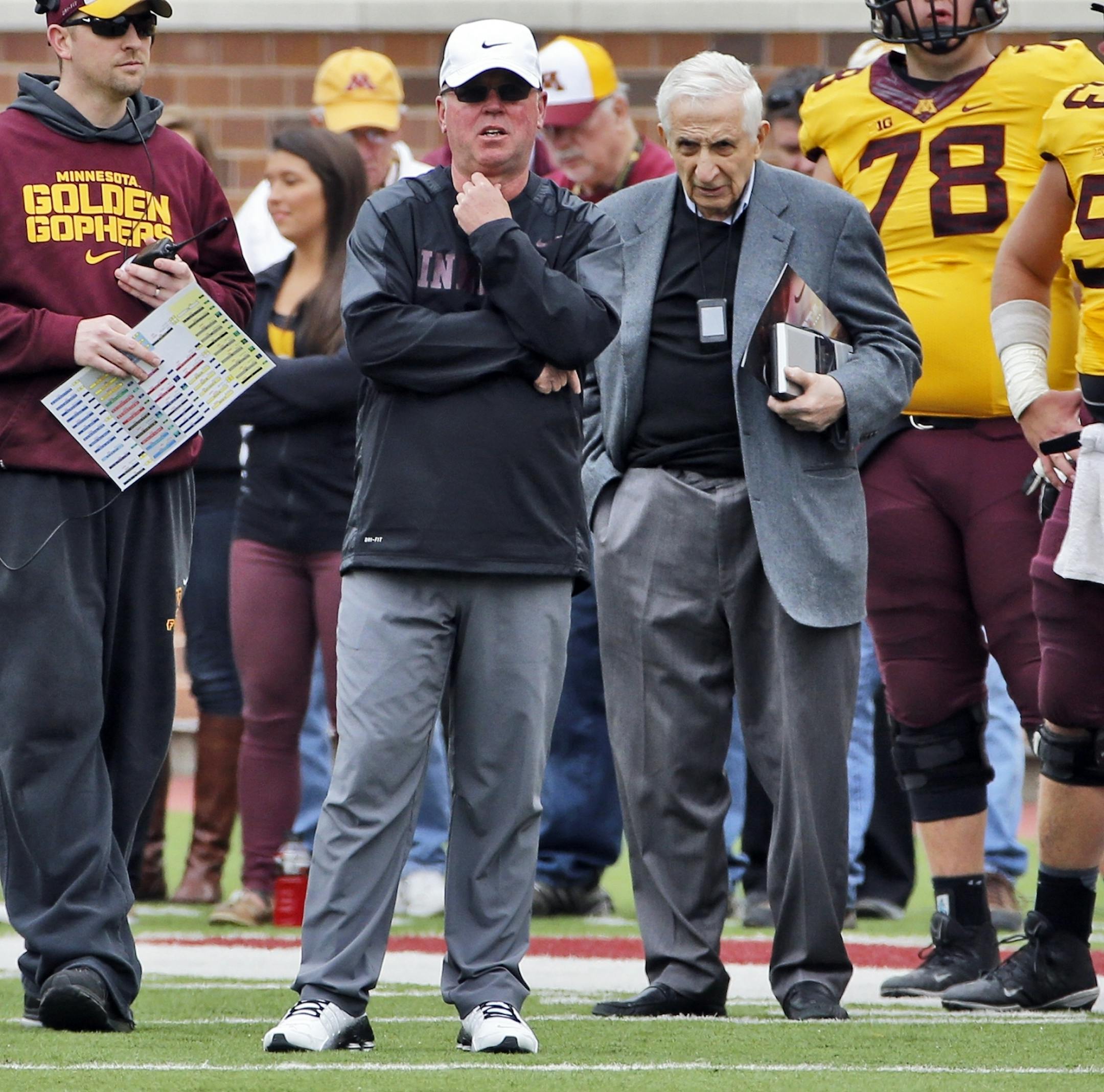 Star Tribune sports columnist Sid Hartman, right, stayed close to head coach Jerry Kill, center.
