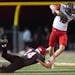 Shakopee quarterback Leyton Kerns (12) tried to escape a tackle by Eden Prairie defensive back Cade Hutchinson (24) in the first quarter. ]