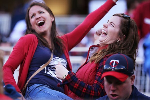 Fans Audrey Heidorn, left, and Michaela Mueller dance during the Twins home opener against the Kansas City Royals at Target Field in Minneapolis on Mo