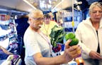 Maya Young purchased a bunch of collard greens and bell peppers as she shopped on The Wilder mobile market bus Tuesday July 14, 2015 in St Paul, MN. ]
