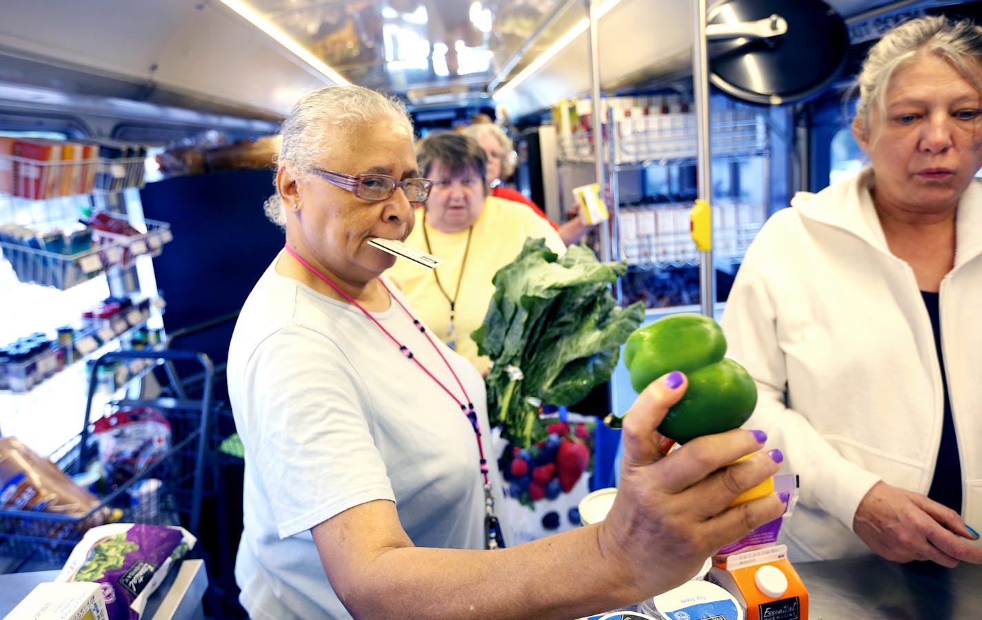 Maya Young purchased a bunch of collard greens and bell peppers as she shopped on The Wilder mobile market bus Tuesday July 14, 2015 in St Paul, MN. ] Jerry Holt/ Jerry.Holt@Startribune.com ORG XMIT: MIN1507141625420254