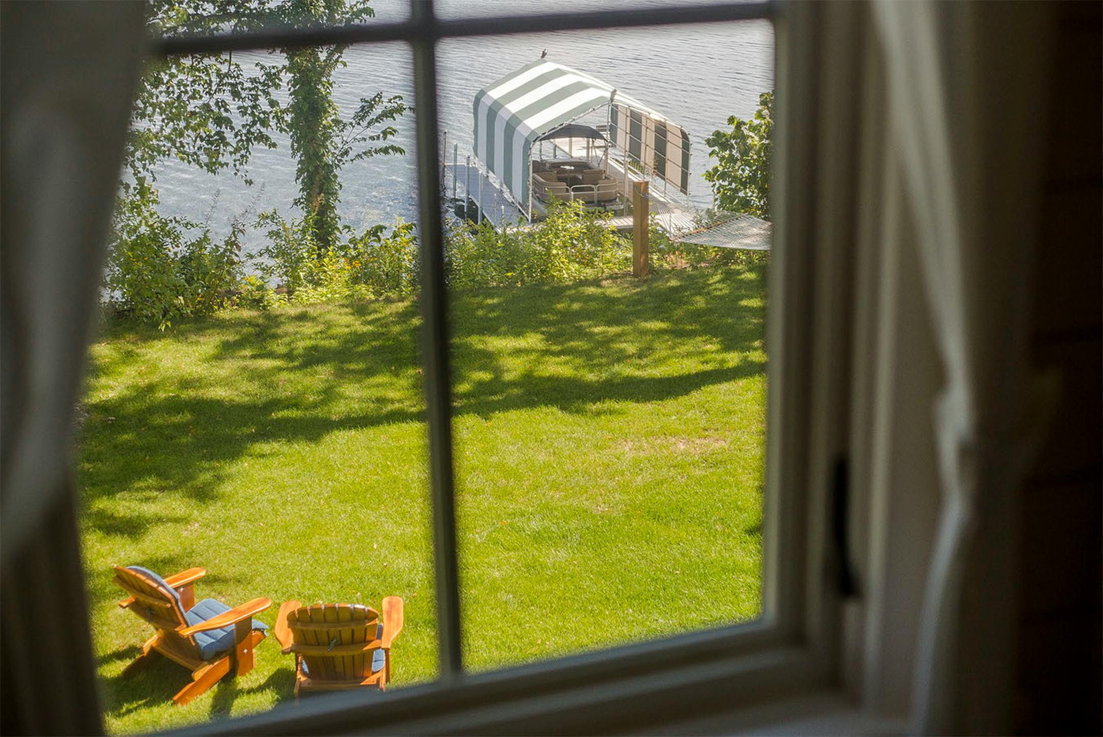 The island cottage is perched at the top of the hill above the Lake MInnetonka shoreline.