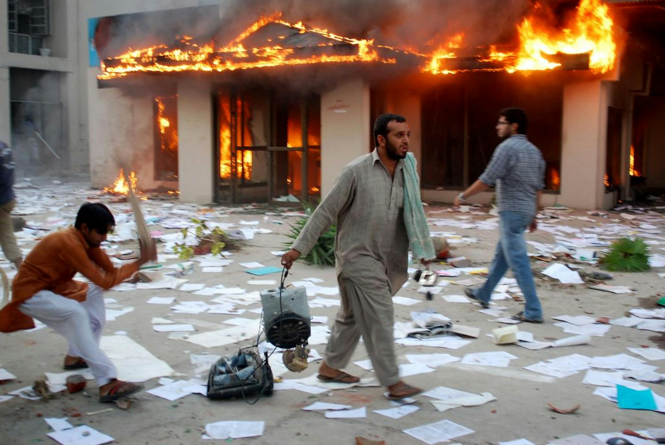 Angry Pakistani protesters seen after setting the electrical company office on fire in Gujranwala near Lahore, Pakistan on Monday, Oct 3, 2011. Hundreds of violent protesters burned vehicles, buildings and a police station reacting over the prolonged power outages in cities. Pakistan is facing a serious power crisis due to mismanagement and corruption.