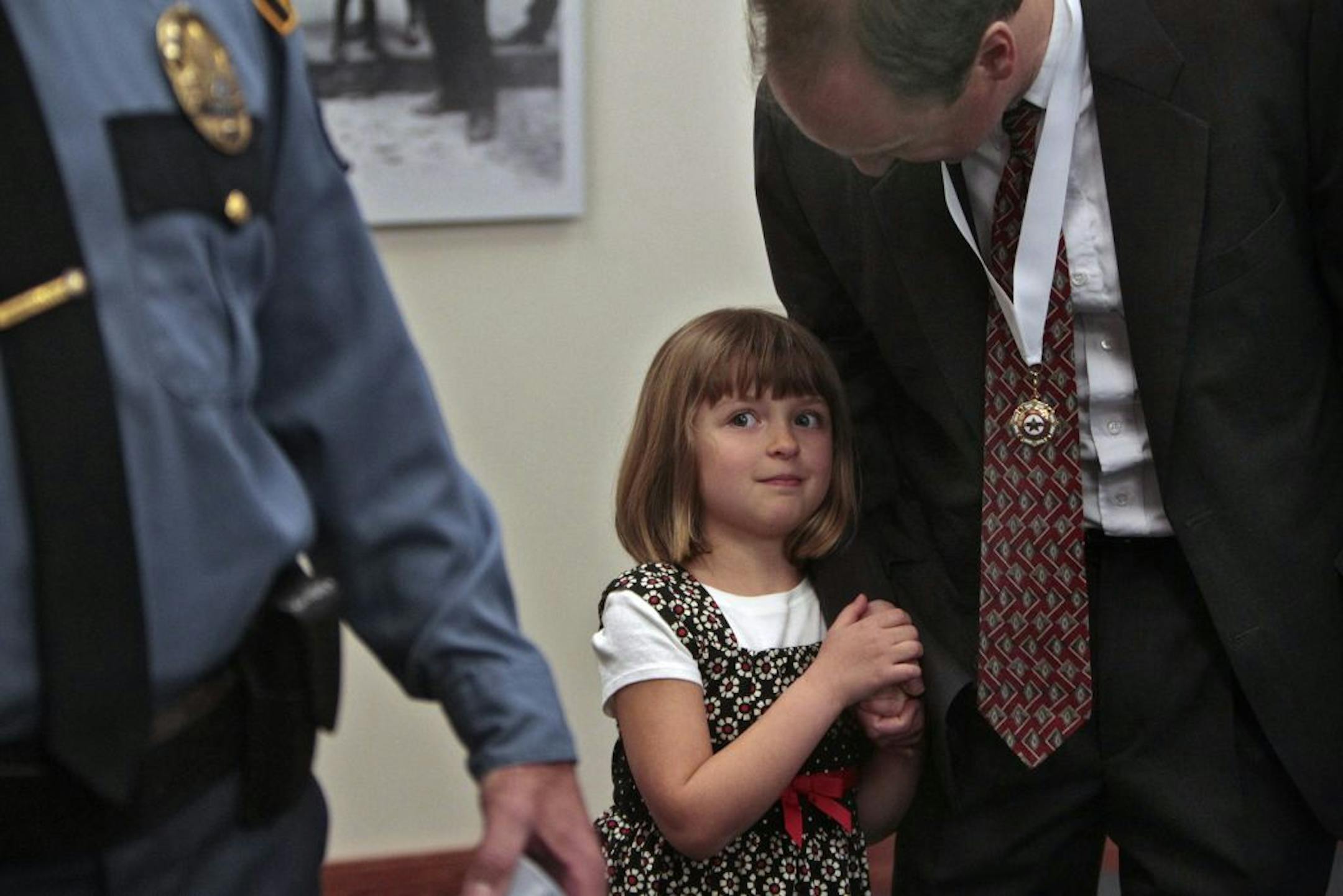 FBI agent Matthew Parker held his daughter's hand after receiving the Chief's Award Thursday. Parker, Sgt. Tom Bergren and several others were honored for their part in the investigation of a triple murder in 2007 and the subsequent prosecution. The tough case was even harder to crack as the two suspects left little physical evidence and intimidated witnesses.