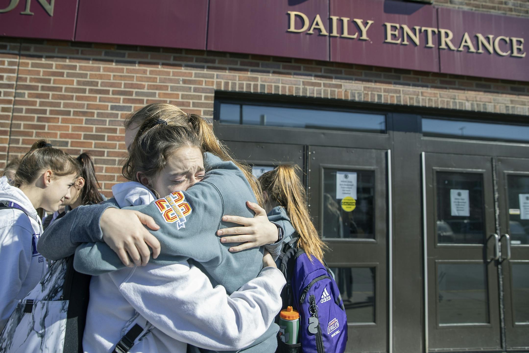Members of the Rochester Lourdes High School girls team including, Marissa Houfek, left, and Ella Hopkins, hugged each other and their teammates after they left Williams arena after the MSHSL announced the cancellation of the Girl's basketball tournament at Williams Arena, Friday, March 13, 2020 in Minneapolis, MN.