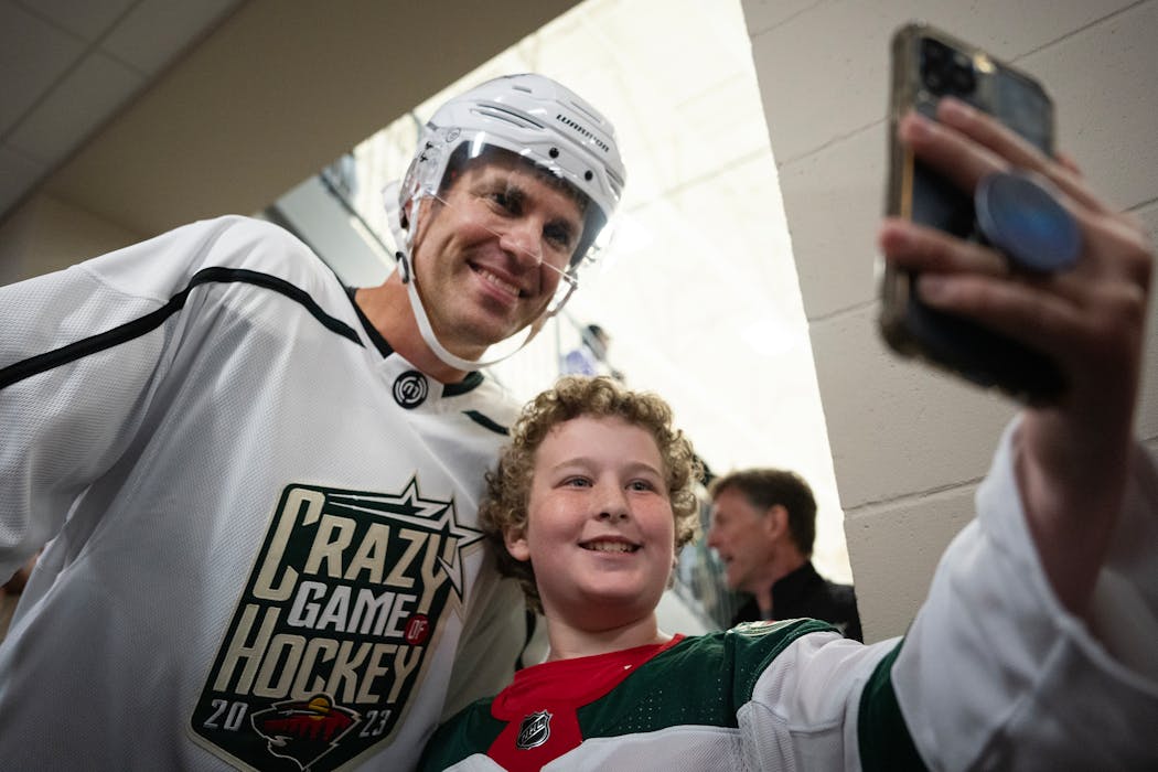 Joe Mauer met a young fan after the “Crazy Game of Hockey” charity event.