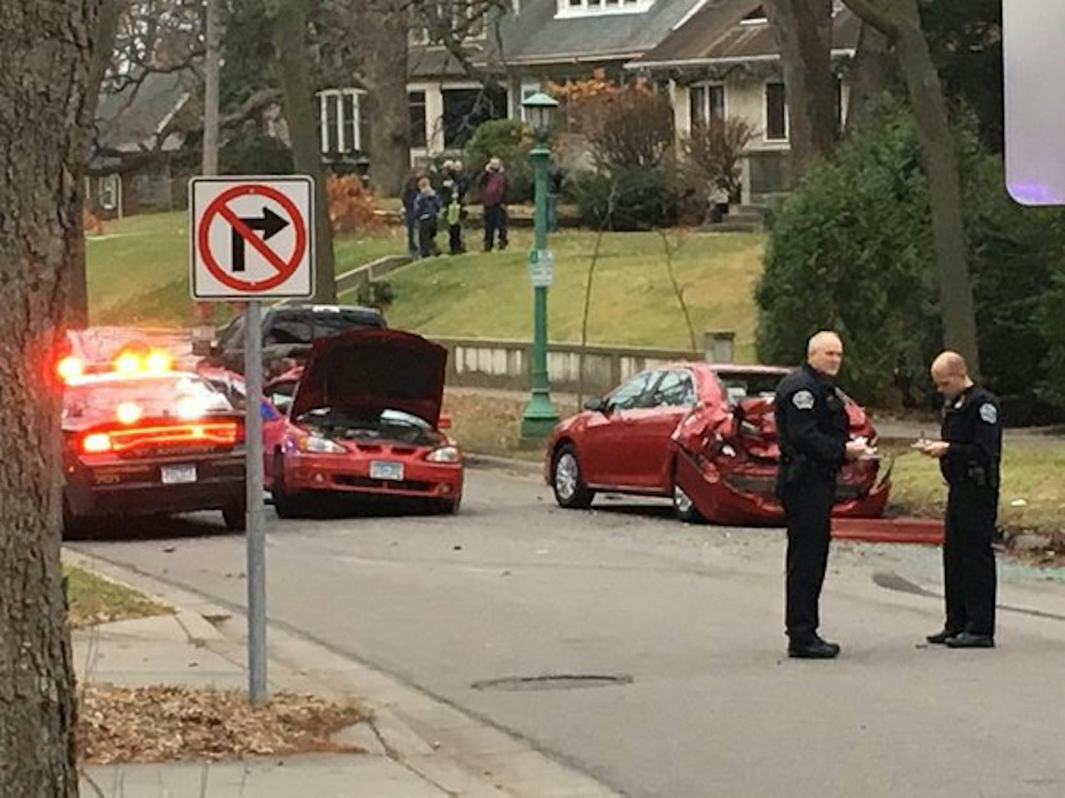 Staff photo by Casey Common: Investigators worked near the scene of a crash on Doswell Avenue in St. Paul on Saturday afternoon. The driver of a car being pursued by St. Anthony police was hurt when his car hit a light pole, then a parked vehicle.