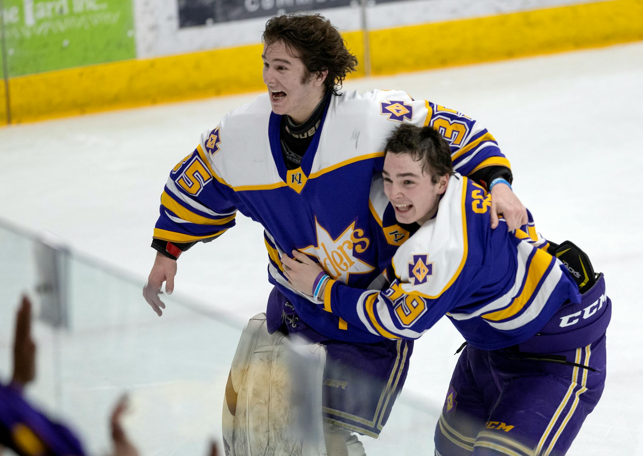 Cretin-Derham Hall goalie Leo Miller (35) and Jake Fisher (18) celebrate at the end of the game.