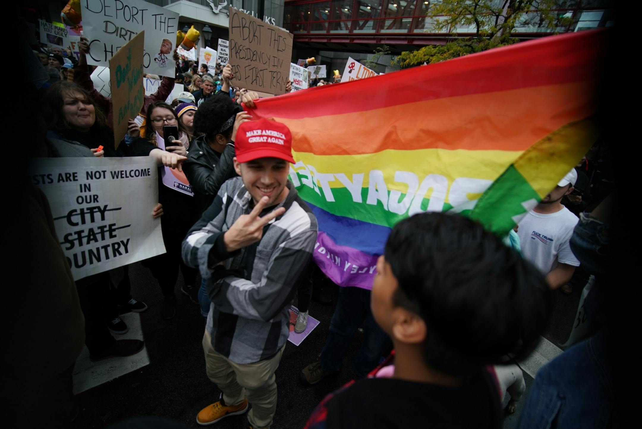 Supporters of and protesters against President Trump interact outside Target Center.