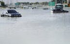 Vehicles sit abandoned in floodwater covering a major road in Dubai, United Arab Emirates, Wednesday, April 17, 2024. Heavy thunderstorms lashed the U
