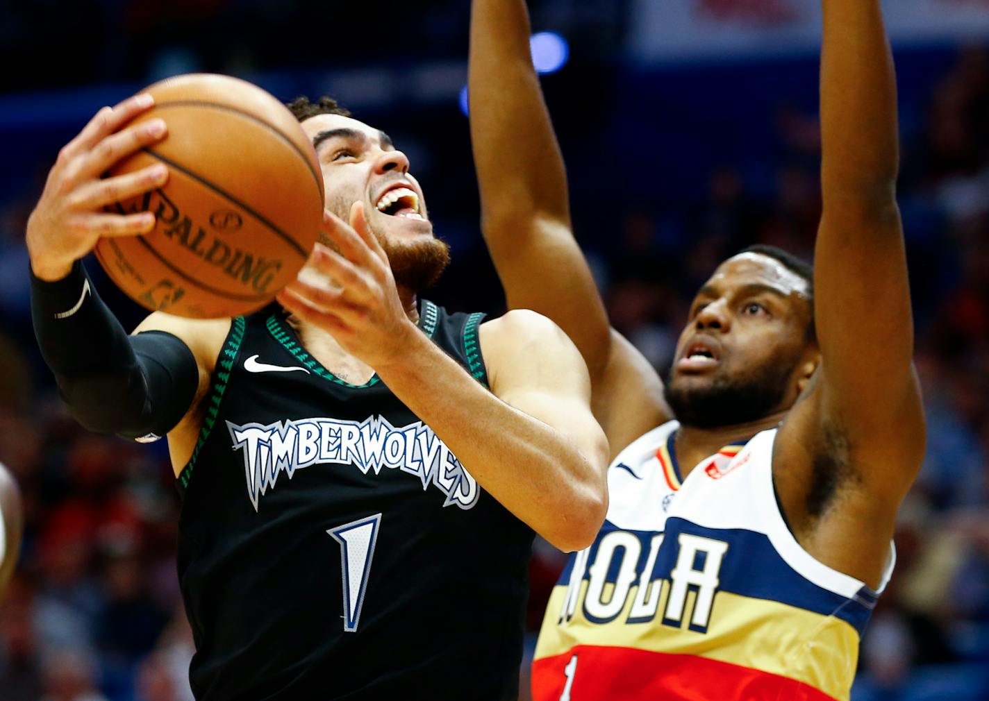 Minnesota Timberwolves guard Tyus Jones, left, shoots as New Orleans Pelicans forward Darius Miller, right,defends during the first half of an NBA basketball game, Monday, Dec. 31, 2018, in New Orleans. (AP Photo/Butch Dill)