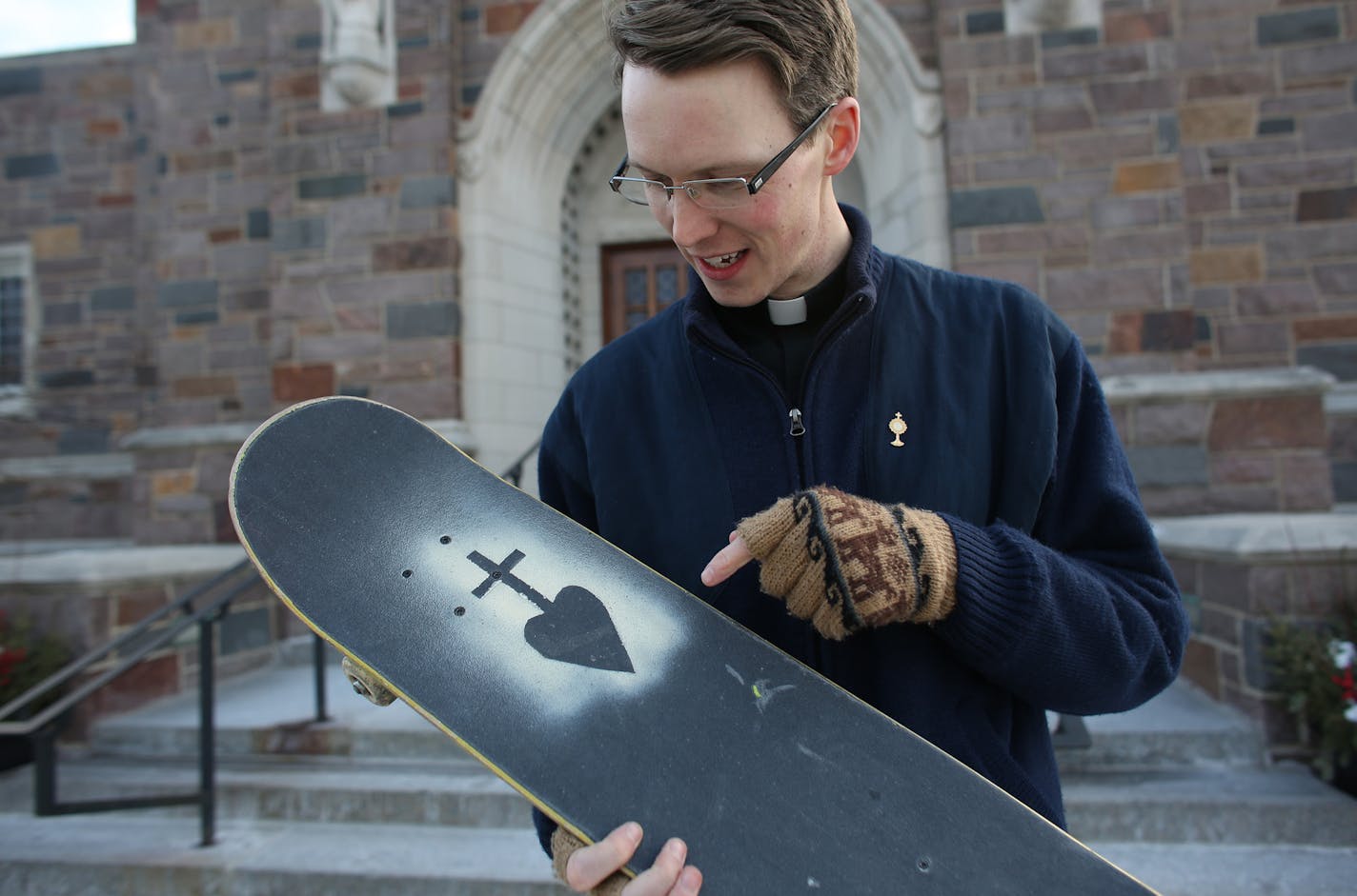 Fr. Andrew Brinkman, 29, showed how he decorated his skateboard in front of the church he worked at. ] (KYNDELL HARKNESS/STAR TRIBUNE) kyndell.harkness@startribune.com At Nativity of Our Lord Church in St. PaulMin., Wednesday, December 17, 2014.