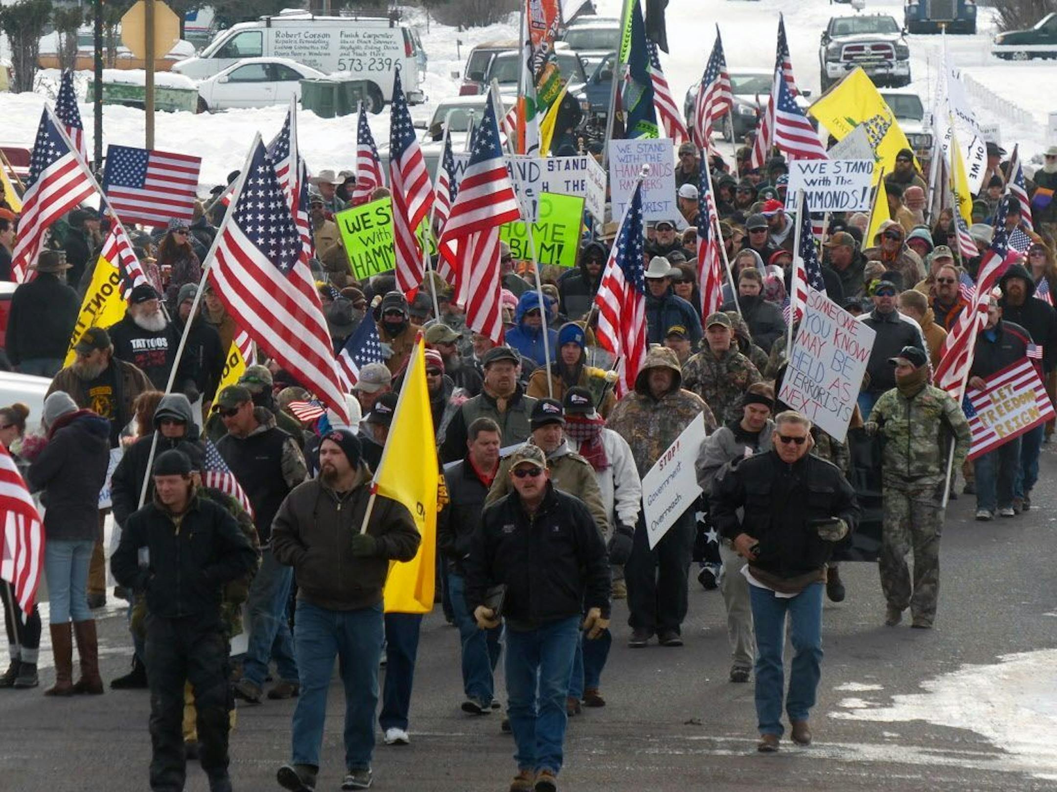 Protesters march on Court Avenue in support of an Oregon ranching family facing jail time for arson in Burns, Ore., Saturday, Jan. 2, 2016. Family members were convicted of the arsons three years ago and served time. But a judge ruled their terms were too short under federal law and ordered them back to prison for about four years each.