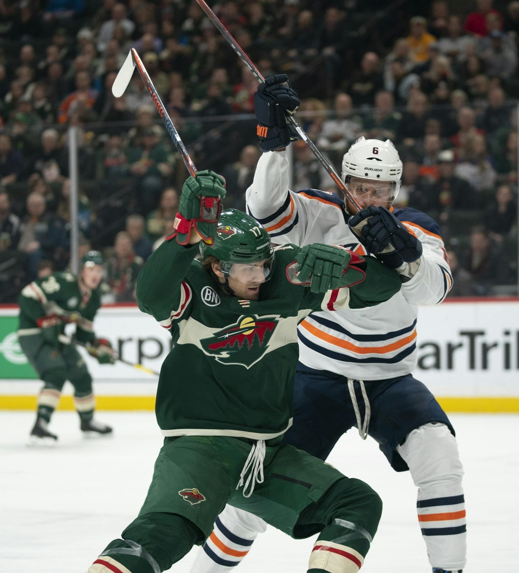Minnesota Wild left wing Marcus Foligno (17) maneuvered arouind Edmonton Oilers defenseman Adam Larsson (6) towards the goal in the first period.