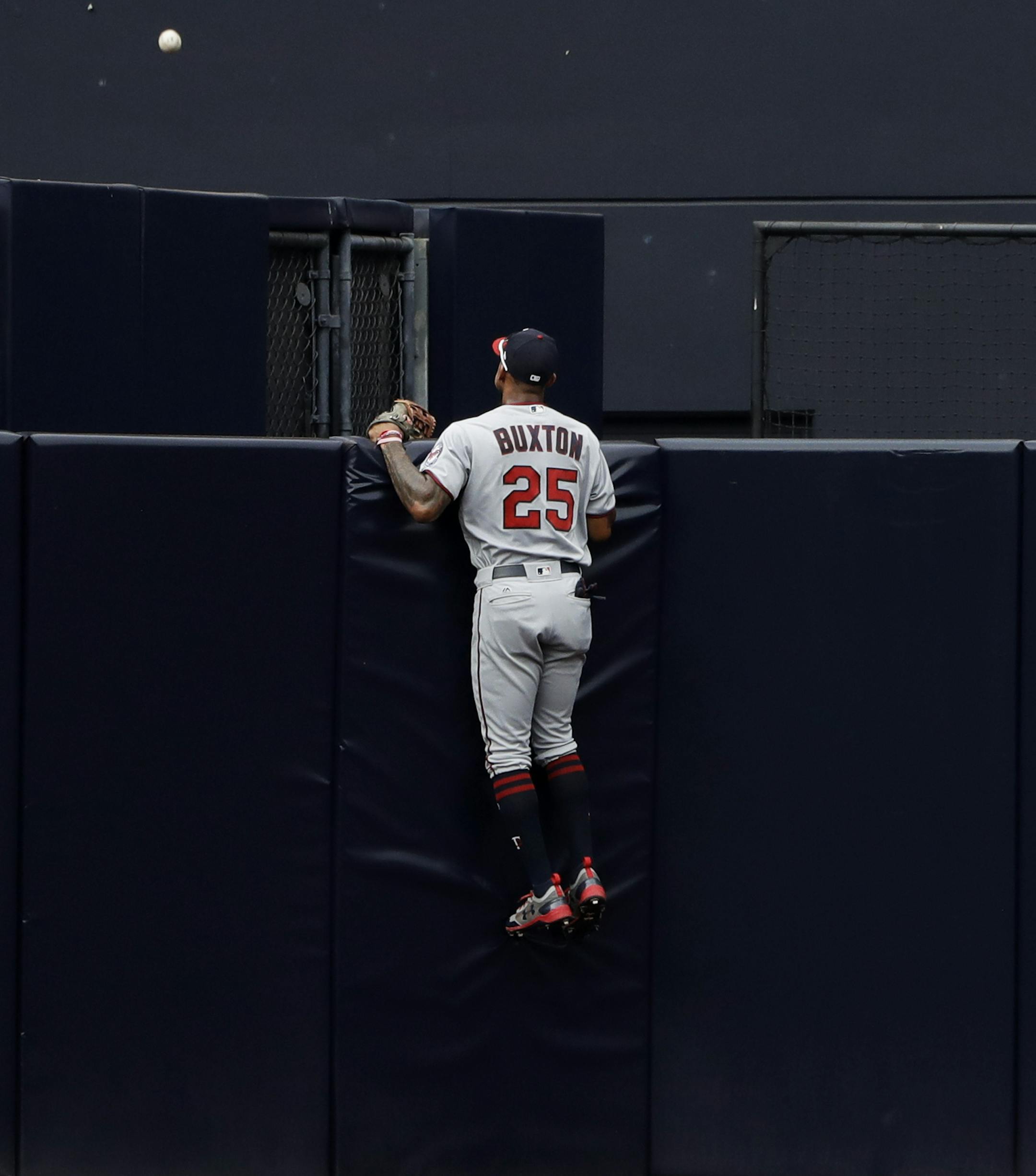 Minnesota Twins center fielder Byron Buxton looks on as a two-run home run hit by San Diego Padres' Jose Pirela goes over the wall during the fourth inning of a baseball game Wednesday, Aug. 2, 2017, in San Diego. (AP Photo/Gregory Bull)