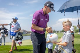 Lee Hodges signs autographs for kids after finishing the round at the PGA Tour's 3M Open.