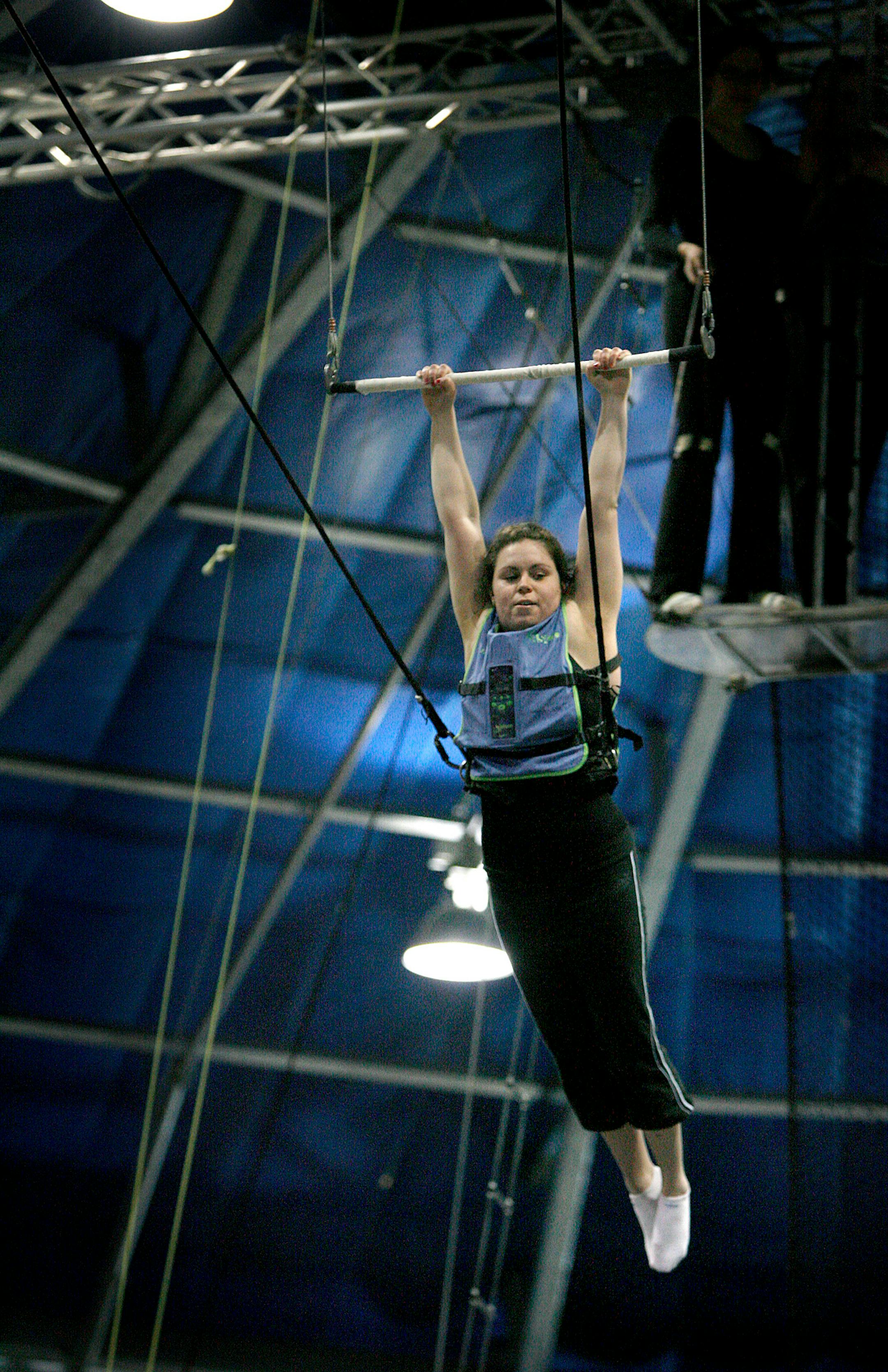 Strapped with a device to collect data, St. Thomas senior Rachel Willenbring swung on a trapeze during an engineering lab with the help of Circus Juventas coaches. Students are studying about dynamics of forces and movement.