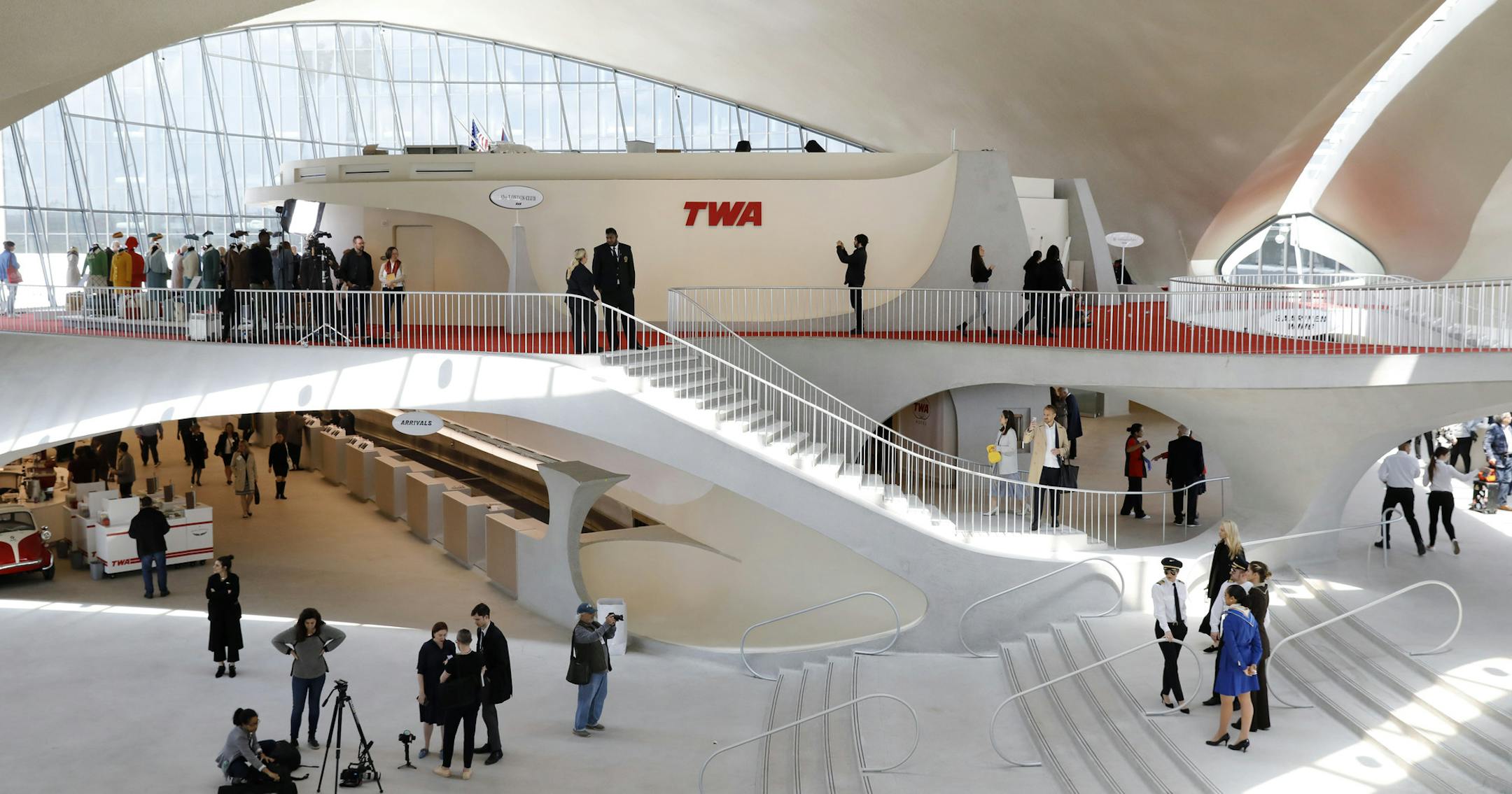 People walk through the lobby of the famous winged TWA terminal at New York's John F. Kennedy Airport Wednesday, May 15, 2019. The Eero Saarinen-designed terminal has opened as a hotel. (AP Photo/Mark Lennihan)
