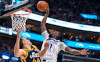 Minnesota Timberwolves center Naz Reid (11) dunks as Utah Jazz forward Bojan Bogdanovic (44) defends during the first half of an NBA basketball game T
