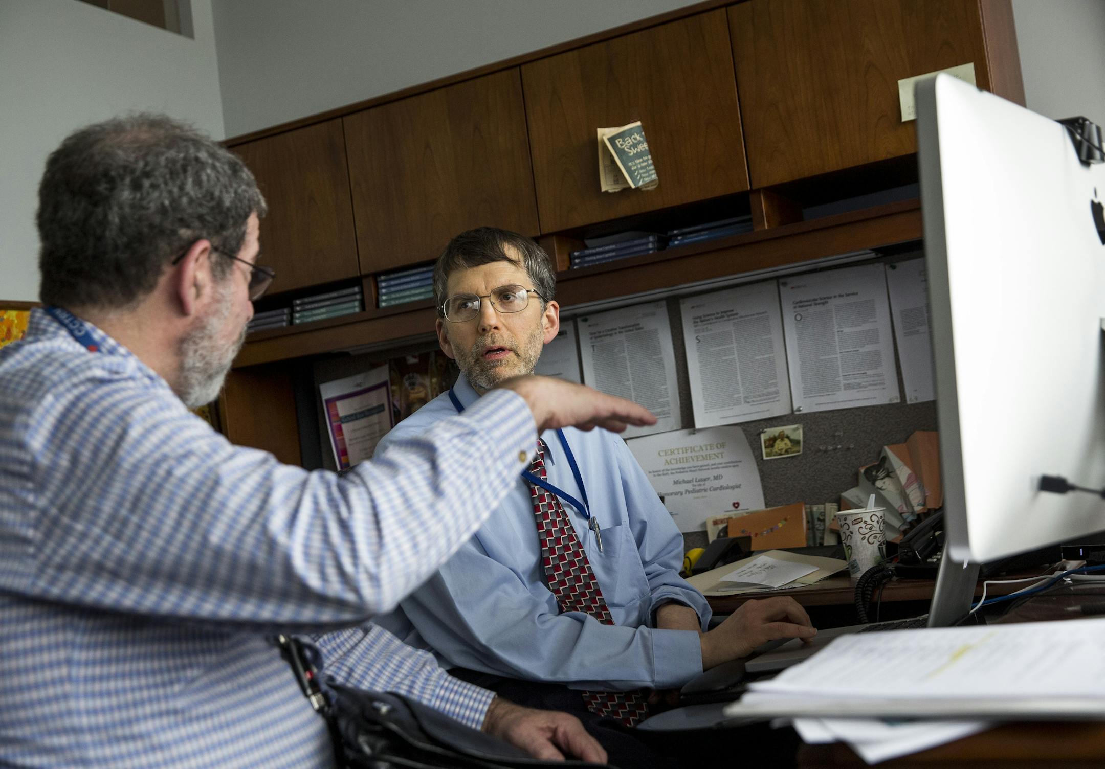 Dr. Michael Lauer, right, a cardiologist and deputy director for extramural research at the National Institutes of Health, talks with Dr. David Gordon of the National Heart, Lung and Blood Institute, in Bethesda, Md., June 17, 2015. Federal health officials acknowledge that money has been squandered on trials and studies that are too small or narrow to yield results with real-world impact. (Drew Angerer/The New York Times)