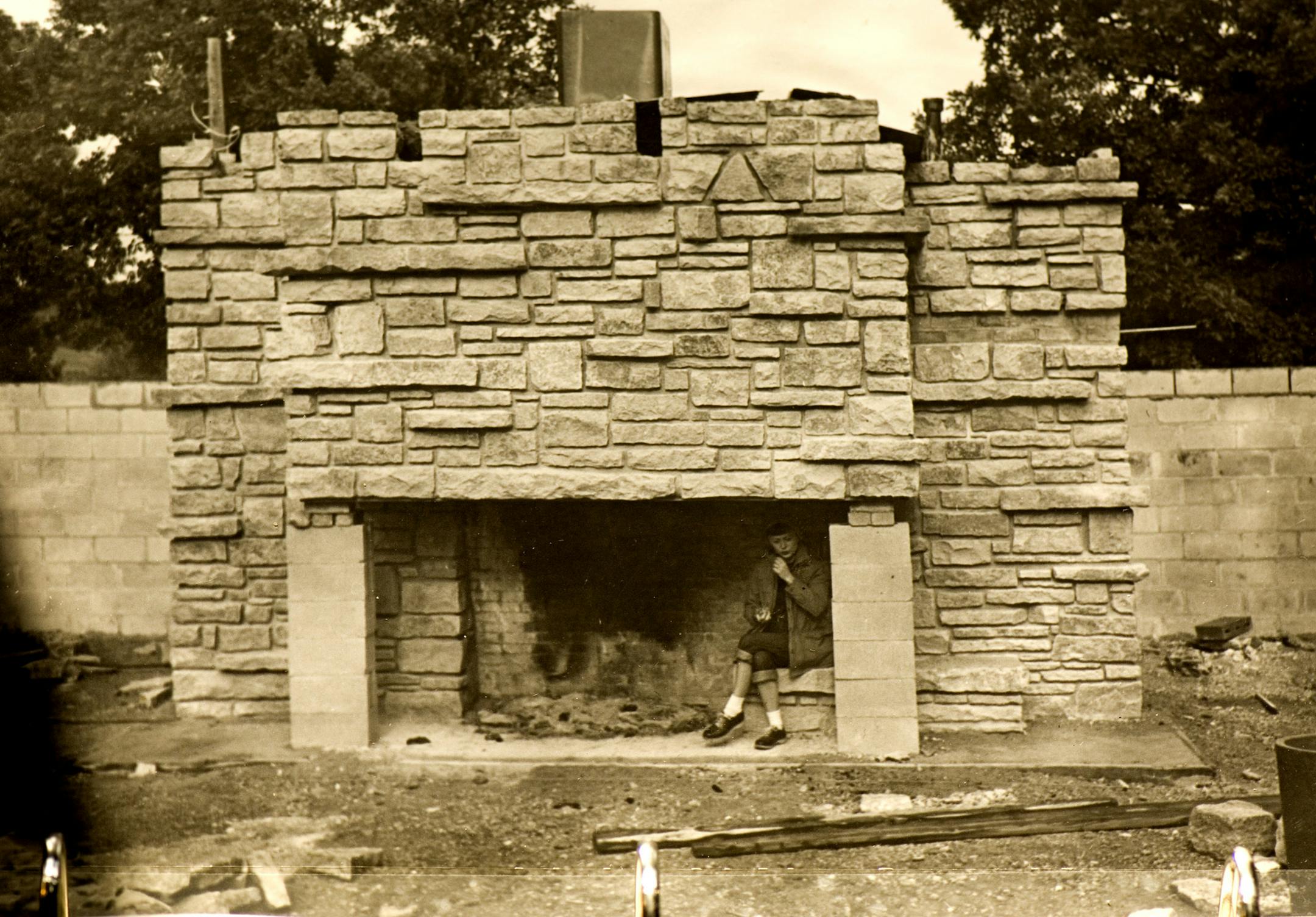 DAVID BREWSTER ï dbrewster@startribune.com Thursday_9/6/07_Stillwater LOVNESS FAMILY PHOTO: Virginia Lovness takes a break on the fireplace hob during the construction of their home in 1955 near Stillwater. She and her late husband built the Frank Lloyd Wright designed home themselves. The stone was Wisconsin Dolomite limestone that they had trucked in.
