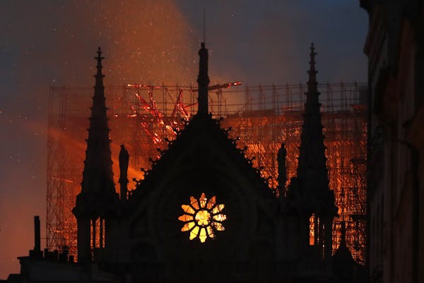 Flames and smoke rise from Notre Dame cathedral as it burns in Paris, Monday, April 15, 2019. Massive plumes of yellow brown smoke is filling the air 