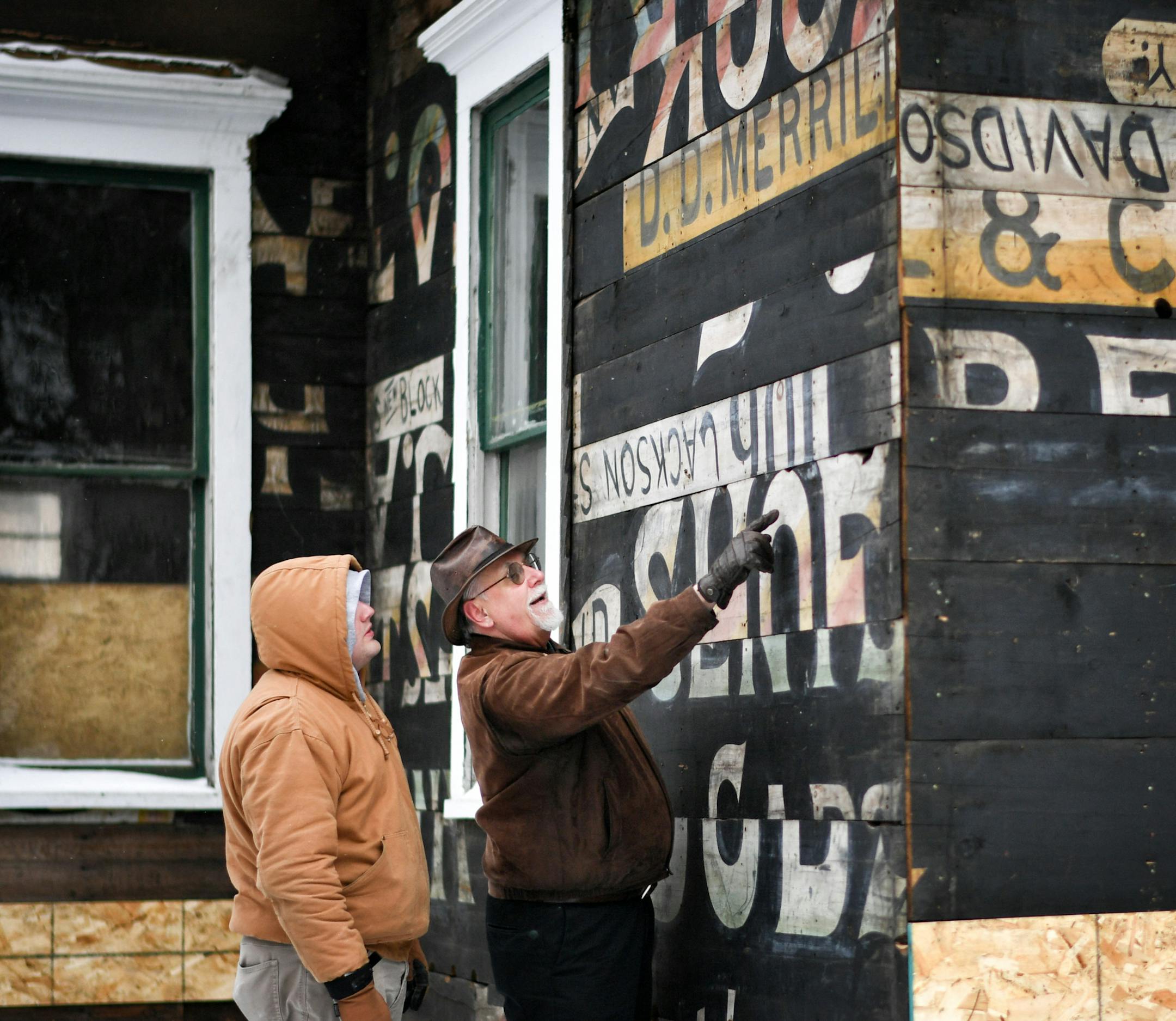 Boards likely from a 1870's era ice skating rink were used to build this St. Paul house. They were uncovered by the owner Todd Johnson, left, during remodeling. He and research historian Jim Sazevich, right, looked over the detail where some names were written in pencil, likely kids waiting at the skating rink.