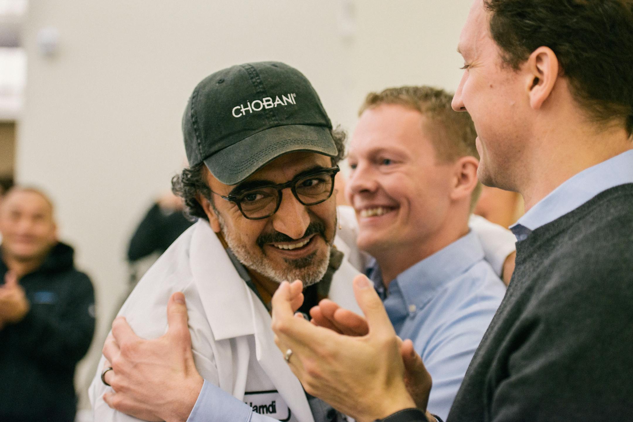 Hamdi Ulukaya, left, a Turkish immigrant who founded the yogurt company Chobani in 2005, during an announcement that he would give employees shares worth up to 10 percent of the company when it goes public or is sold, in New Berlin, N.Y., April 26, 2016. The ownership stake in the yogurt company could make some of the 2,000 full-time employees into millionaires. (Alexandra Hootnick/The New York Times)