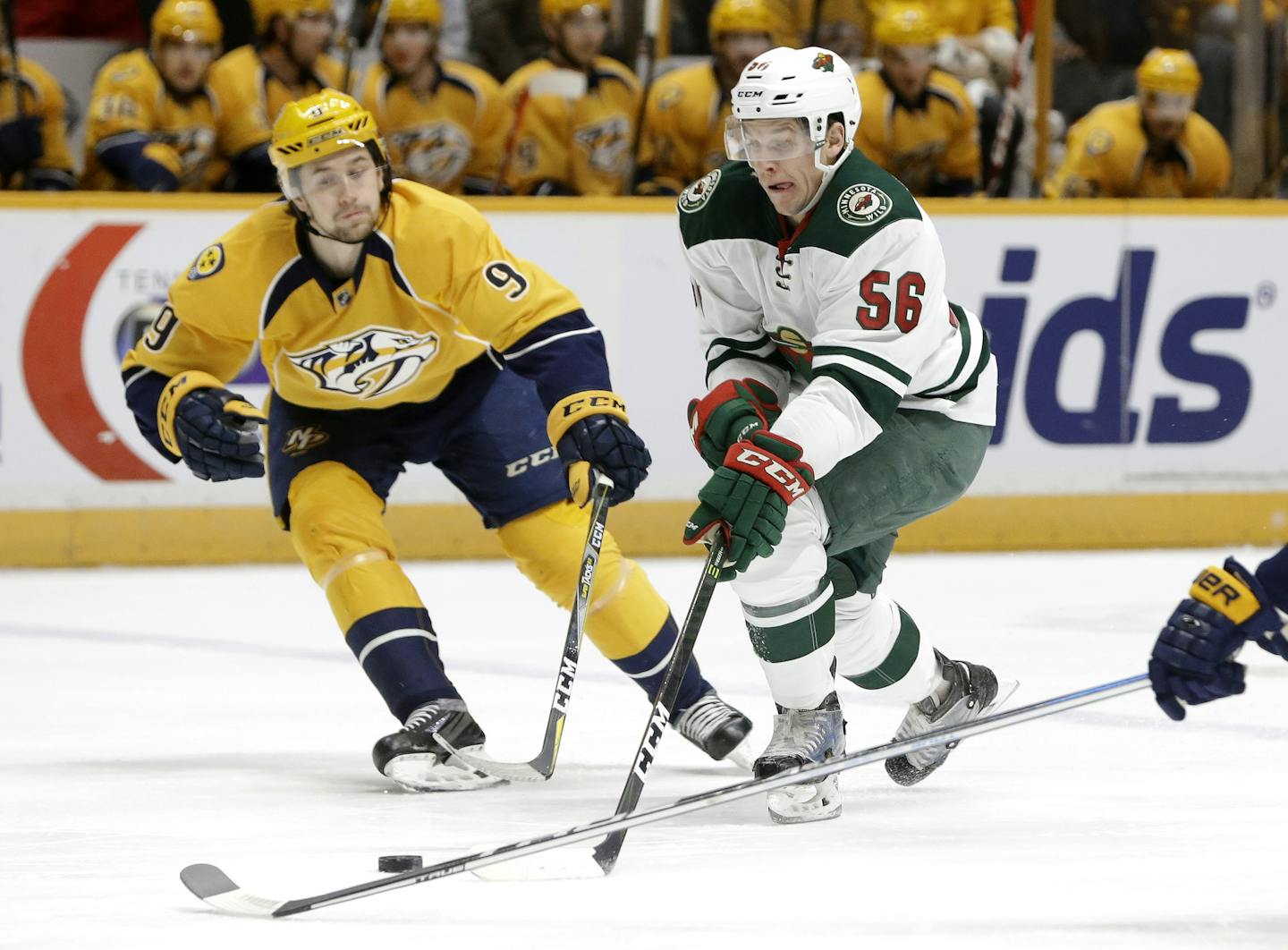 Minnesota Wild center Erik Haula (56), of Finland, moves the puck past Nashville Predators left wing Filip Forsberg (9), of Sweden, during the first period of an NHL hockey game Thursday, Dec. 15, 2016, in Nashville, Tenn. (AP Photo/Mark Humphrey)