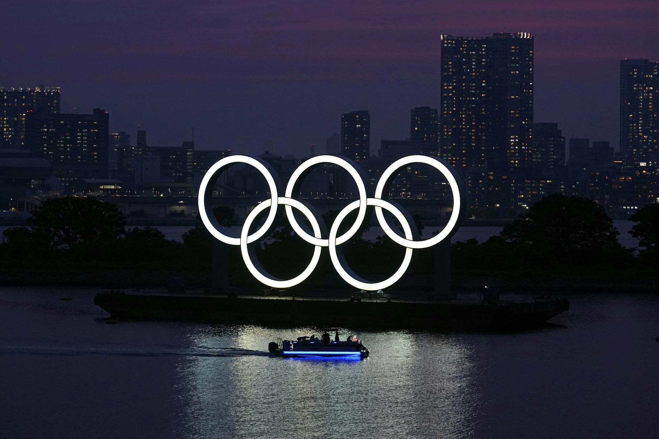 FILE - In this June 3, 2020, photo, the Olympic rings float in the water at sunset in the Odaiba section in Tokyo. Masa Takaya, the spokesman for the Tokyo Olympics, said Thursday, July 9, 2020, he's confident the postponed games can be held in 2021 despite a recent poll in Japan in which 77% of respondents said they did not believe the games could be held next year. (AP Photo/Eugene Hoshiko, File)