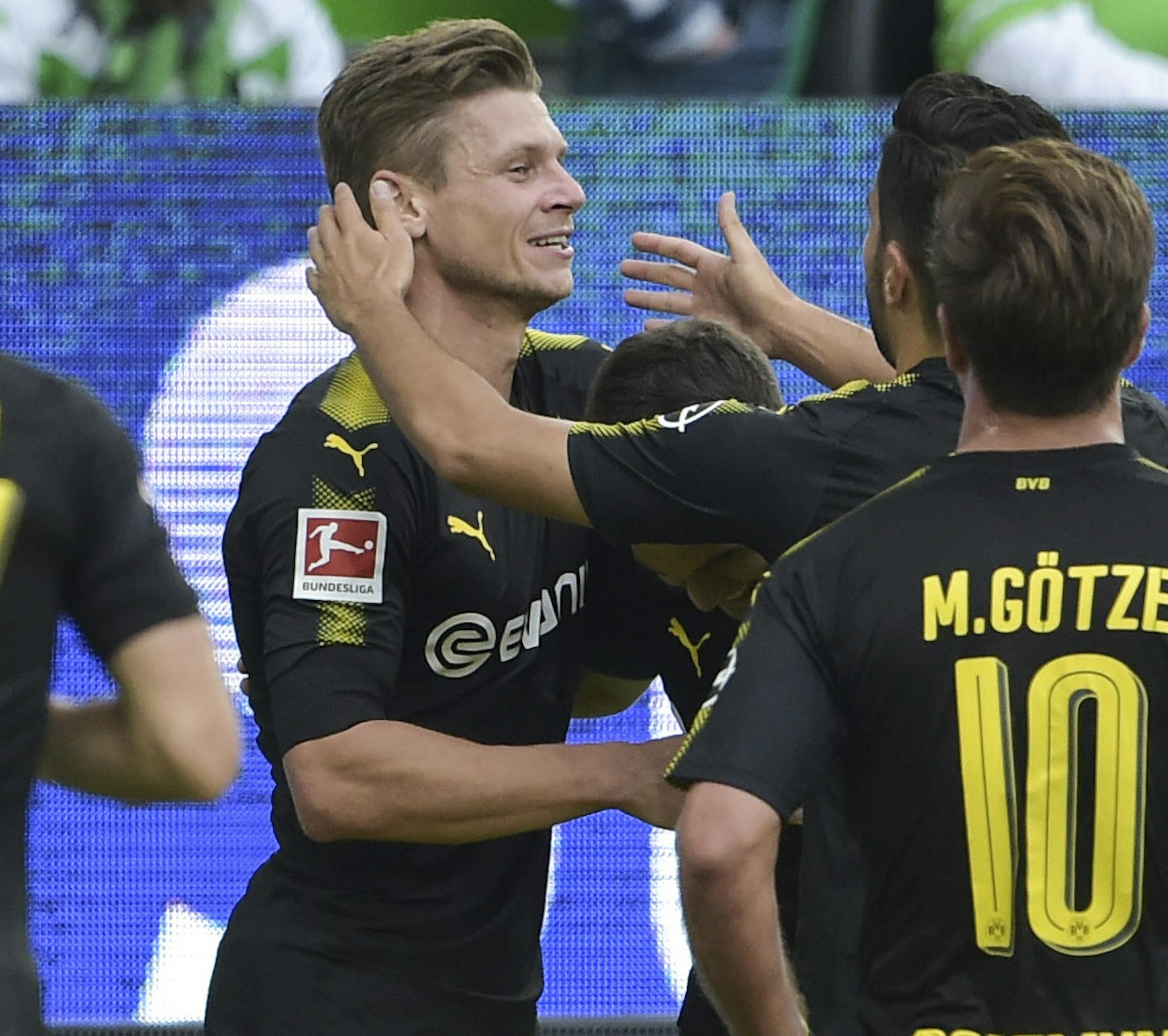 Dortmund players celebrate the first goal of the game scored by Christian Pulisic centre, against Wolfsburg, during the German Bundesliga soccer match between VfL Wolfsburg and Borussia Dortmund in the Volkswagen Arena in Wolfsburg, Germany, Saturday Aug. 19, 2017. (Silas Stein/dpa via AP)