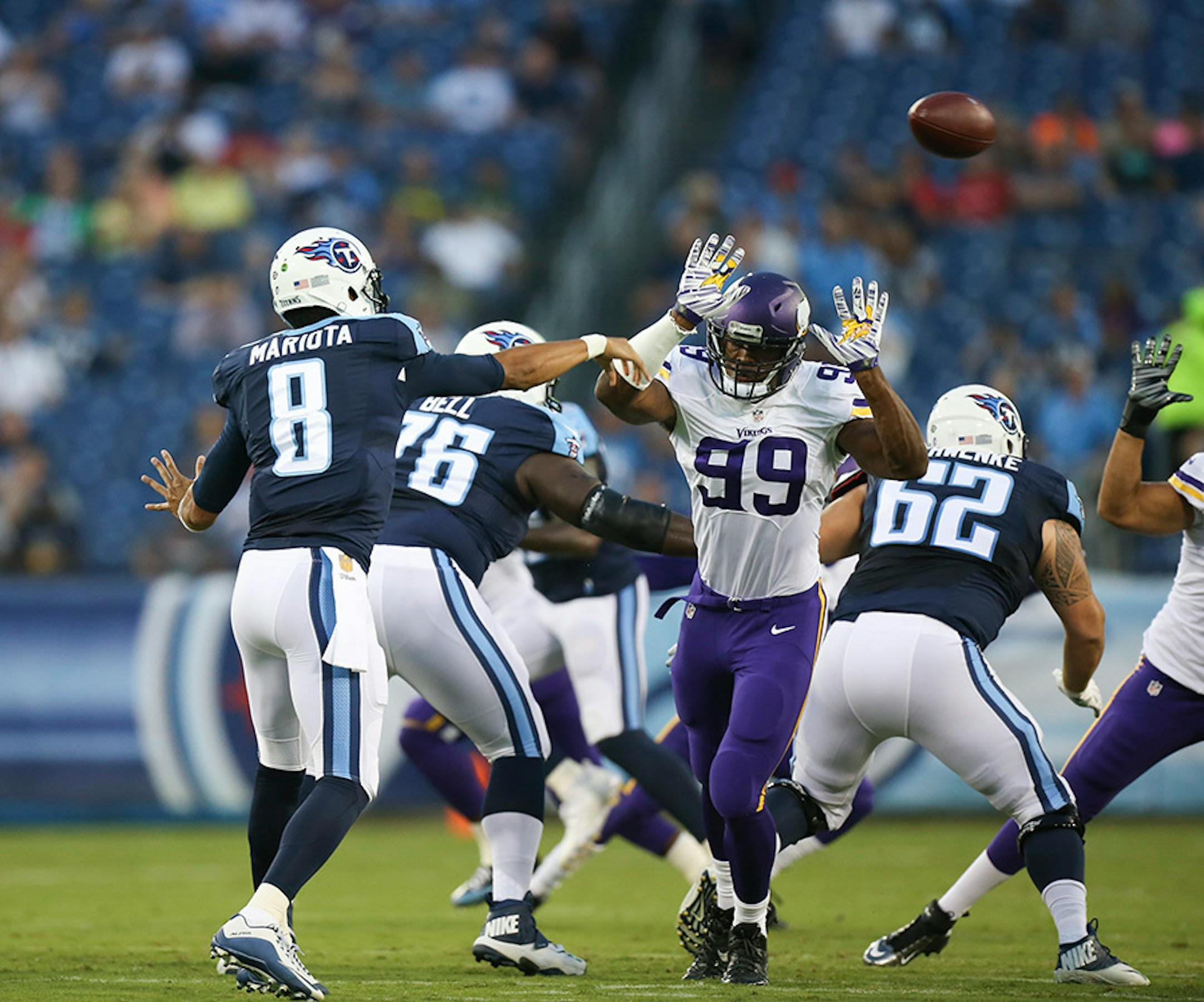 Tennessee Titans quarterback Marcus Mariota (8) threw a short pass to wide receiver Harry Douglas who then went 59 yards for a touchdown in the first quarter Thursday night. Vikings defensive end Danielle Hunter (99) pressured Mariota.