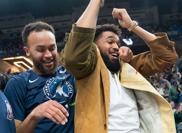Minnesota Timberwolves forward Kyle Anderson (5) and center Karl-Anthony Towns (32) react to a dunk by Minnesota Timberwolves center Naz Reid (11) aga