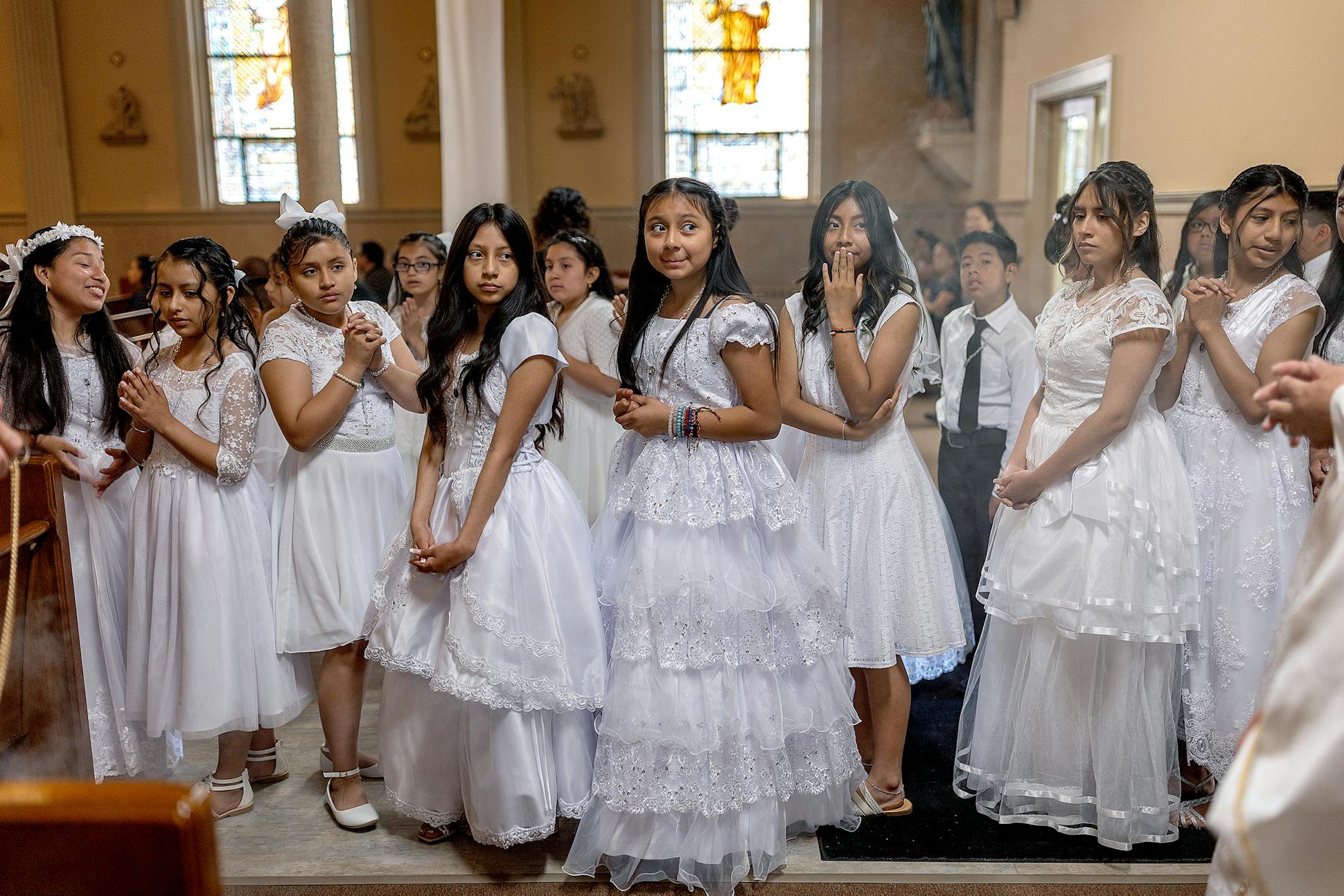 Young girls and boys line up to make their way down the aisle for their first communion at Saints Cyril and Methodius Church.